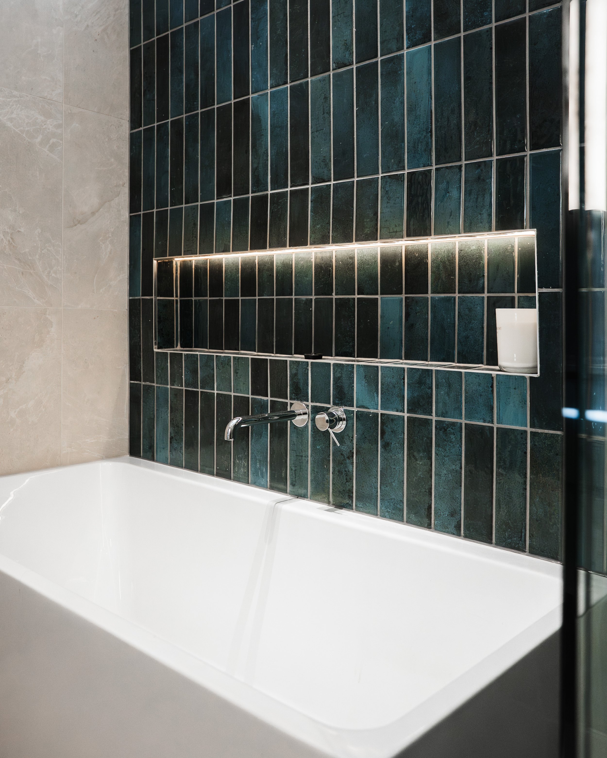 Freestanding bath against a deep green vertical-tiled feature wall with a backlit niche, ensuite renovation in Yarraville by Lúrae Studio