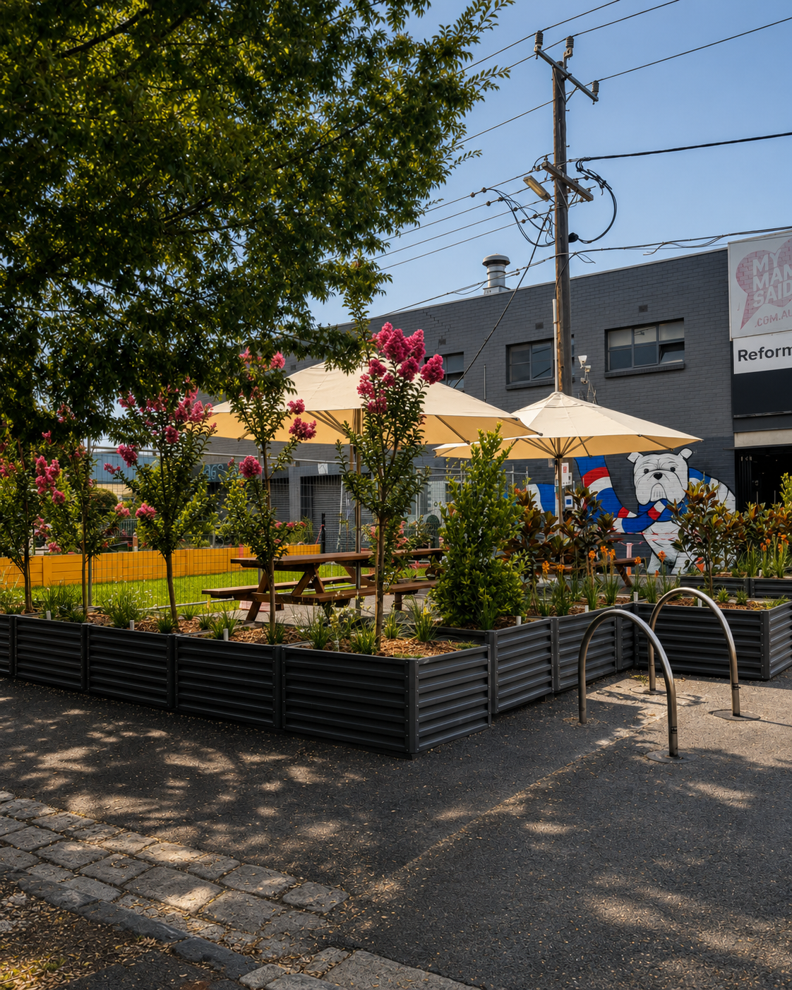 Seddon Village pedestrian park in Melbourne’s inner west, featuring landscaped gardens, outdoor seating, bike racks and the distinctive bulldog mural.
