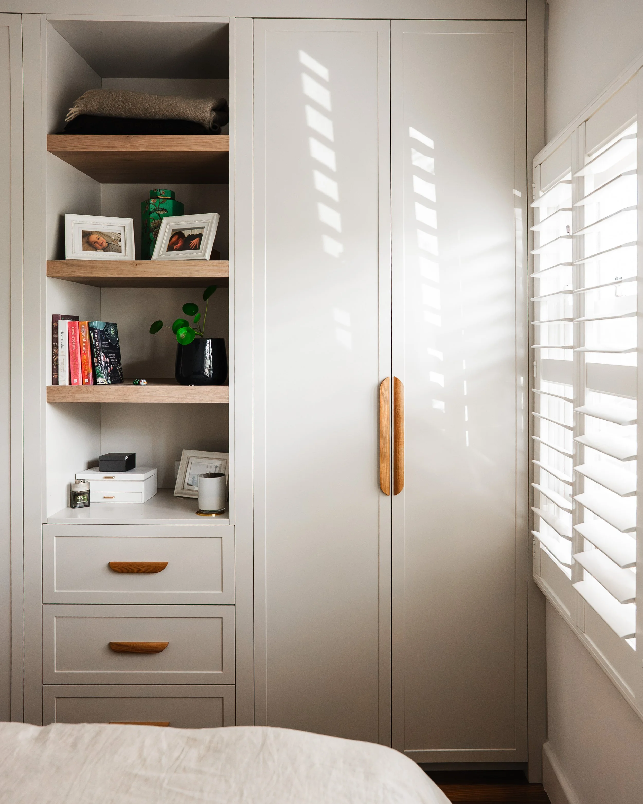 Bespoke bedroom wardrobe with timber handles and open shelving, Yarraville renovation by Lúrae Studio