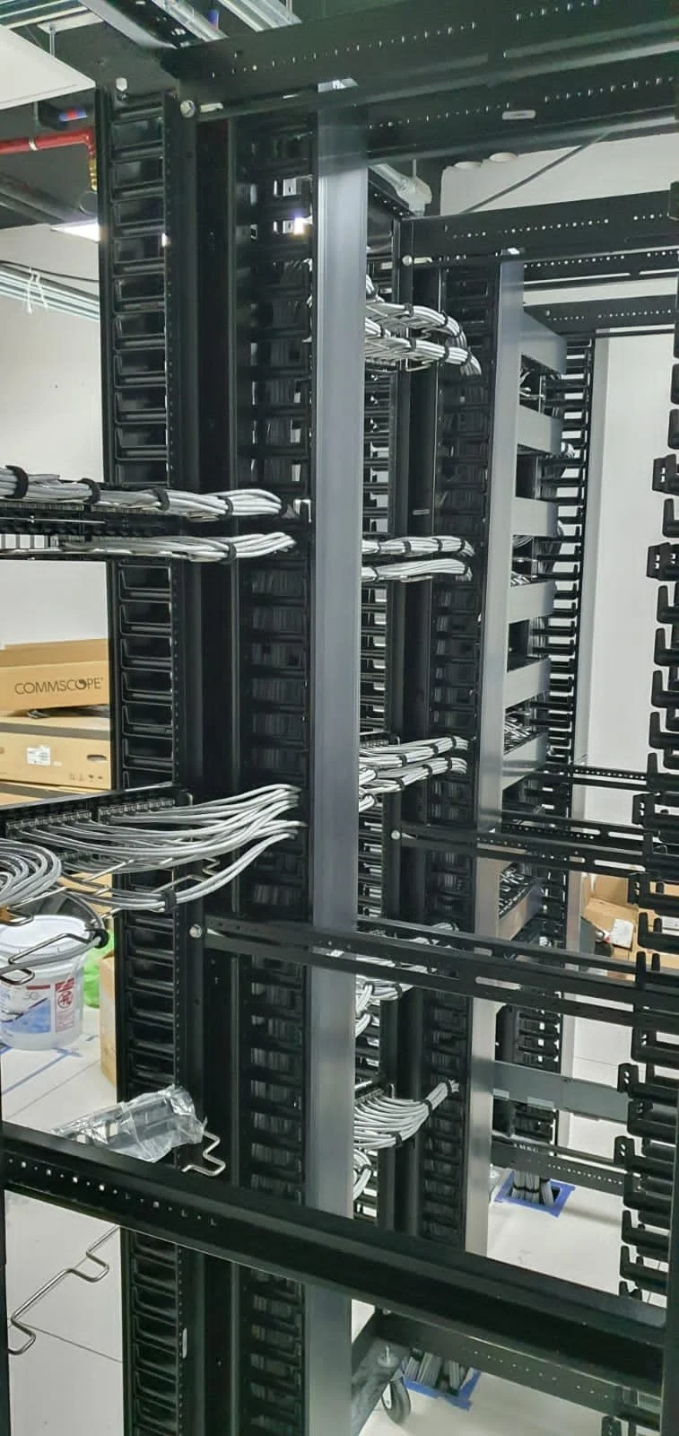 Una estructura de rack de servidores con cables blancos conectados entre los equipos, en un entorno de centro de datos.