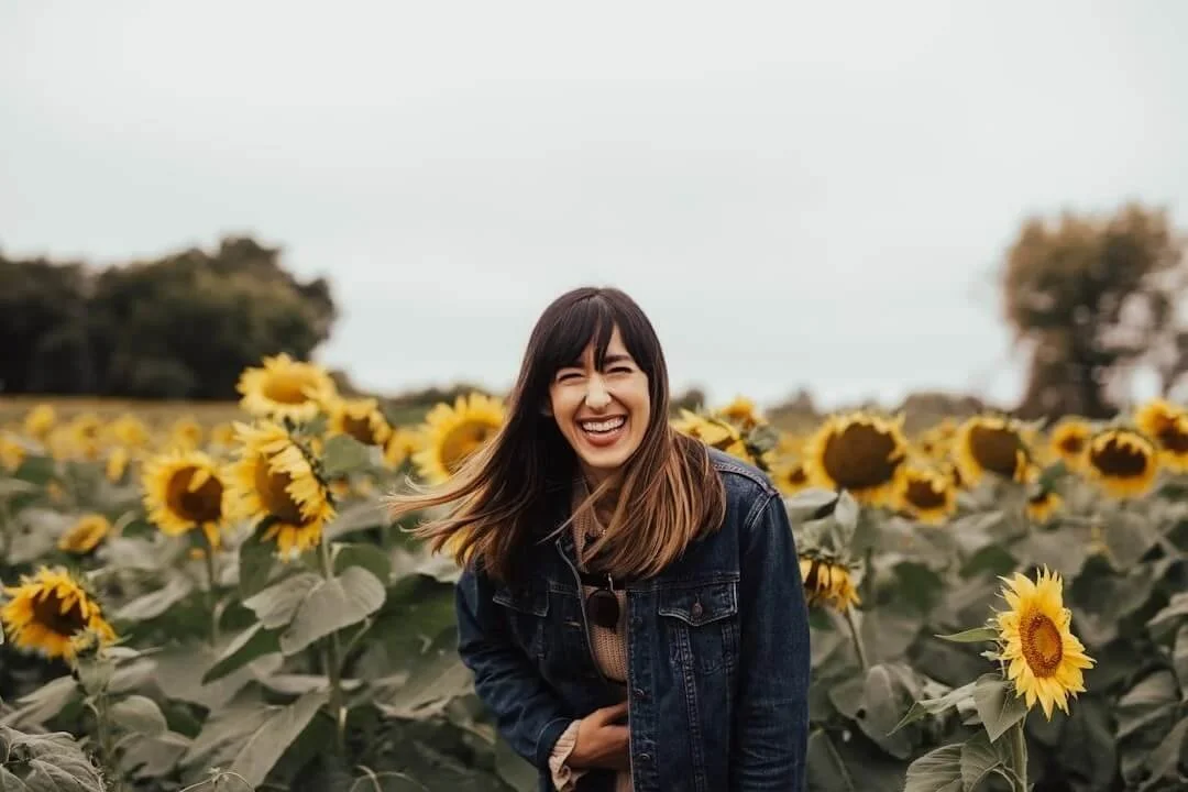 brainspotting therapist orange county woman smiling in field of flower wearing jean jacket