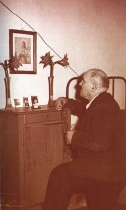 Alessandro praying in front of an image of Maria that he kept in his room