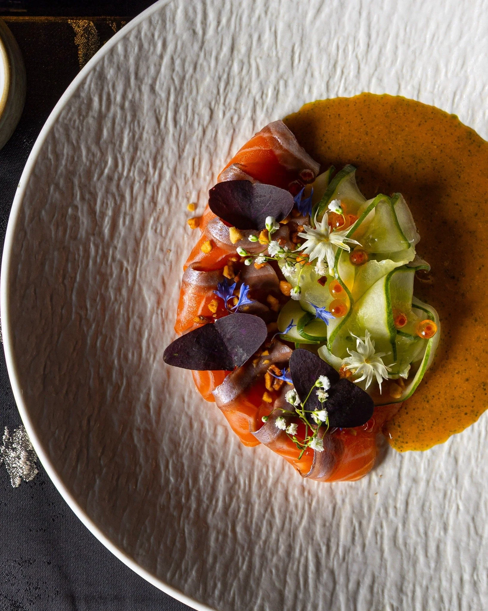TAS salmon is built around freshness and contrast.

Paired with mango, cucumber, dill oil, wild oxalis, and fried wonton, the &ldquo;SSS&rdquo; element, spicy, sour, and sweet, brings layered complexity to the dish. Each component works together to h