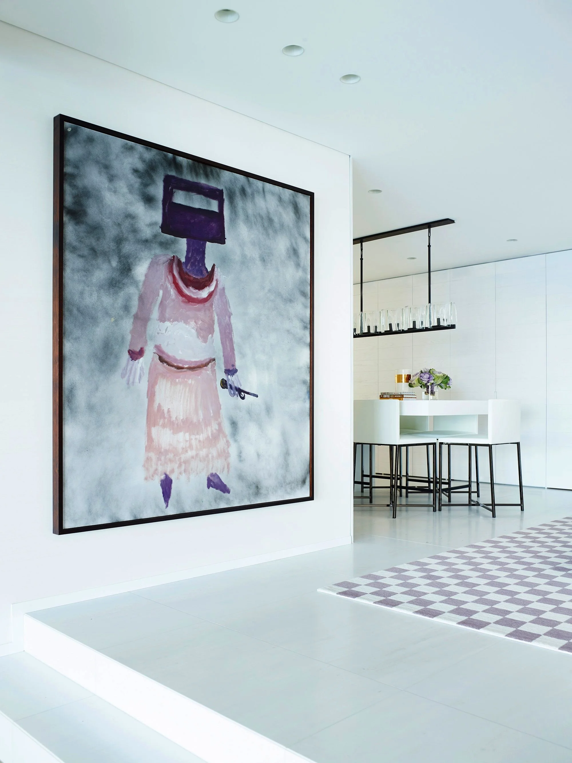 Modern art gallery featuring a large abstract painting of a figure with a large square head, wearing a pink dress, standing against a textured grey background.