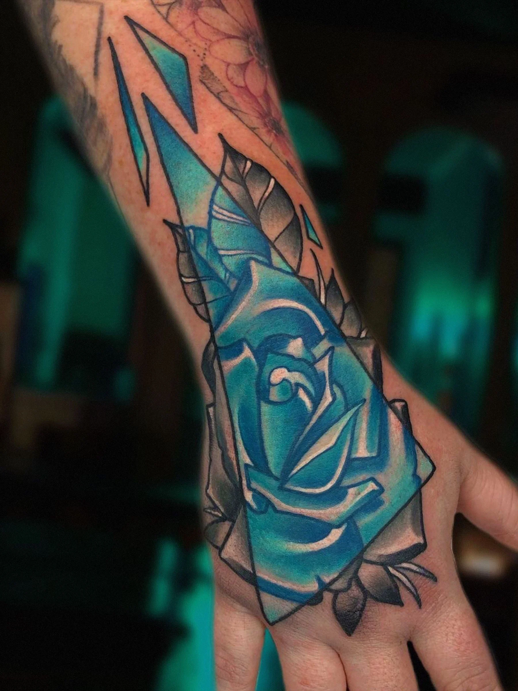 Blue geometric rose hand tattoo with color accents by Shane Klos in Evansville, Indiana