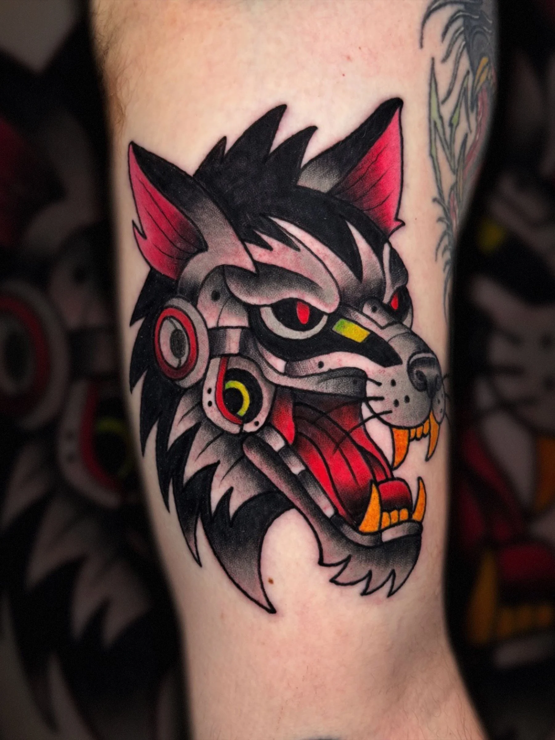 Cyber wolf tattoo with red accents and mechanical details by Evansville tattoo artist Shane Klos