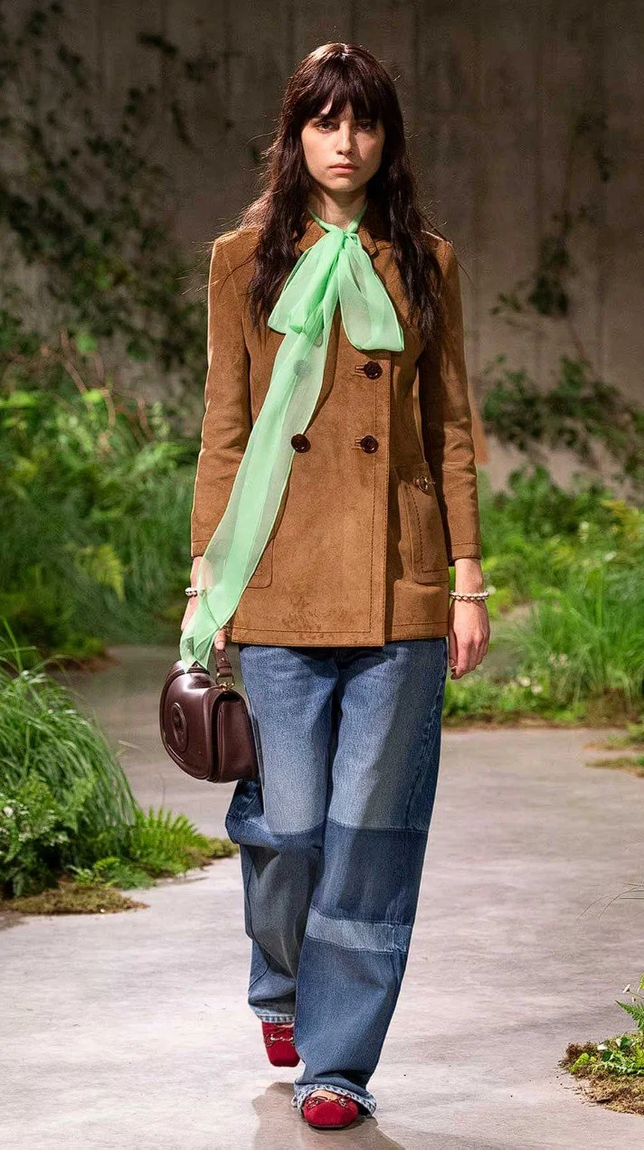 look-5-at-the-gucci-cruise-2025,-with-an-organza-pussy-bow-in-mint-green-flowing-on-top-of-a-suede-buttoned-up-brown-jacket,-baggy-jeans-and-ancora-red-flat-shoes.jpg