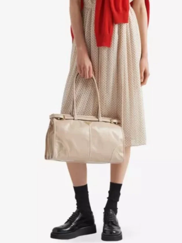 "PRADA Logo-plaque large leather top-handle bag buy" "Shop PRADA top-handle bag with logo plaque" "PRADA large leather top-handle bag for everyday use" "Luxury PRADA logo top-handle bag"