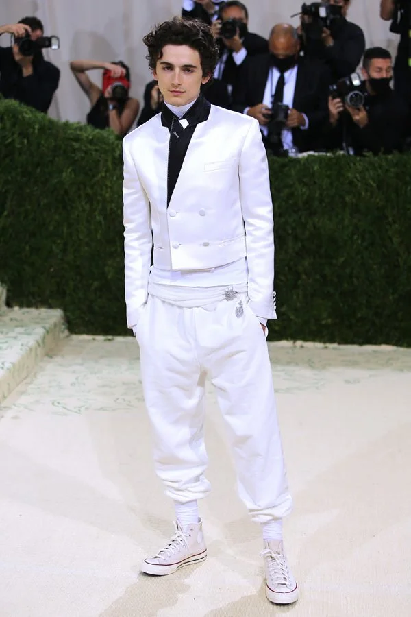 Timothée Chalamet wearing a white Haider Ackermann suit and Converse sneakers at the 2021 Met Gala