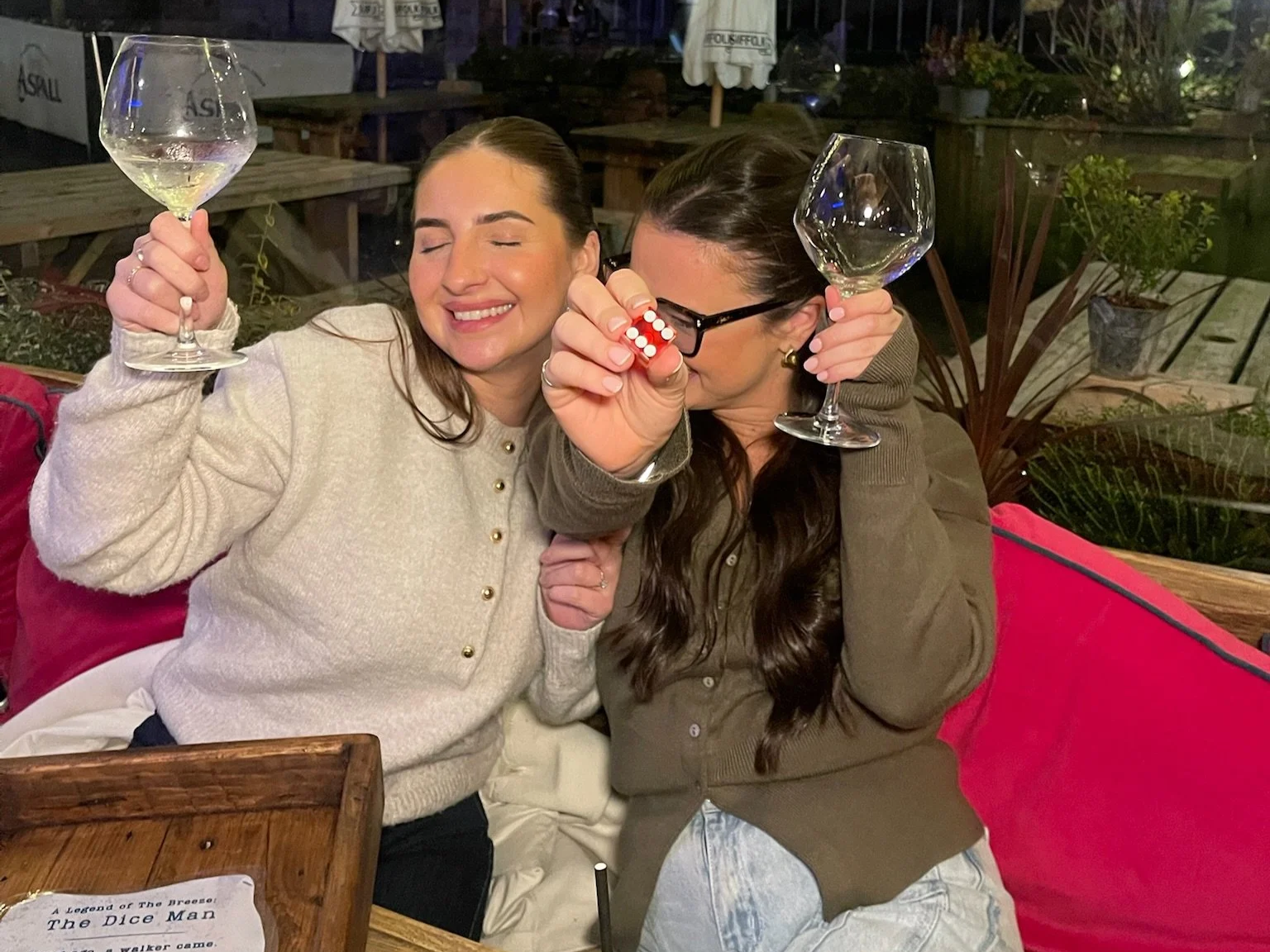 two girls rolling a 6 dice man meal for free