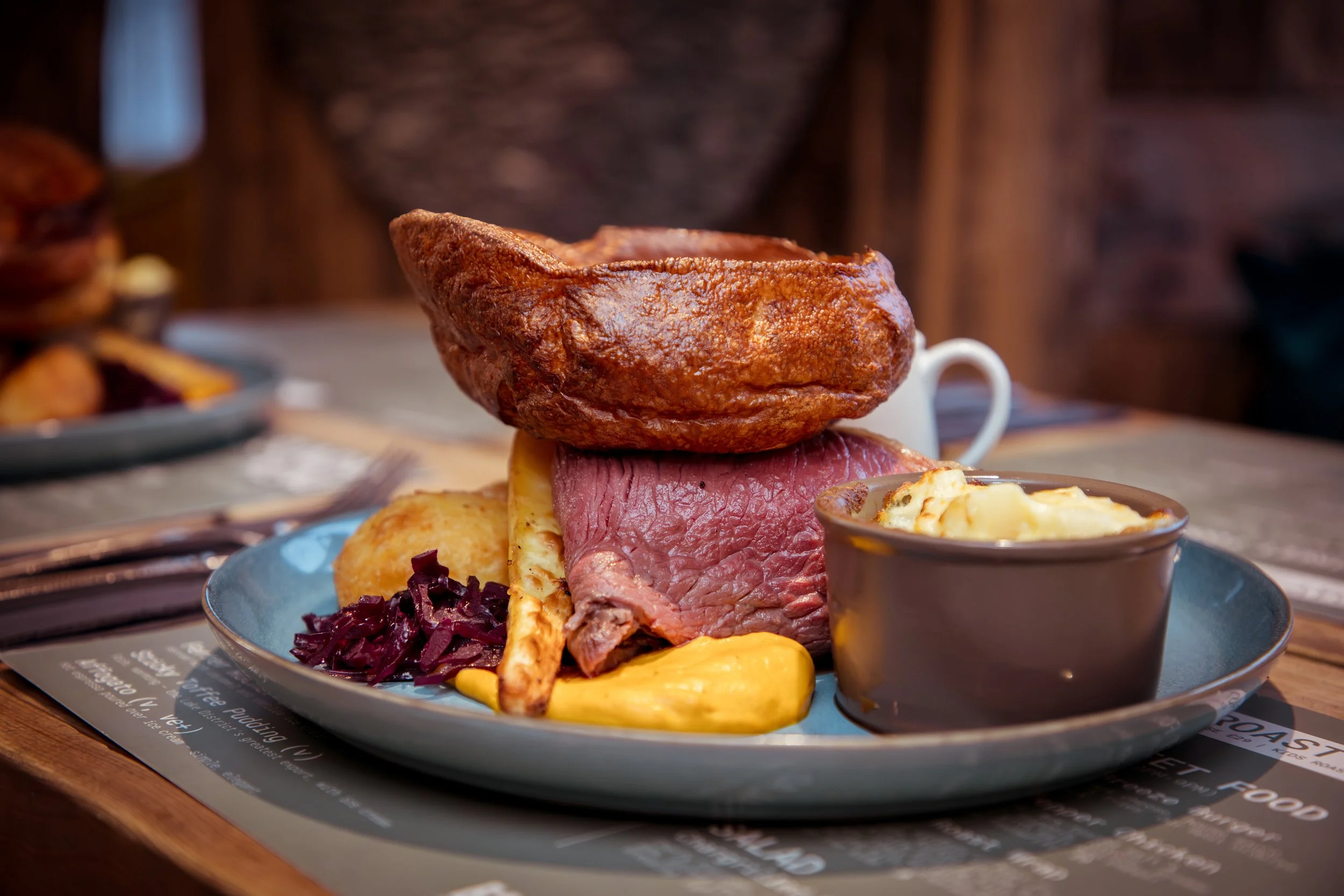 roast dinner with roast potatoes, mash, glazed carrot, seasonal veg, cauli cheese & Yorkshire pudding and gravy.