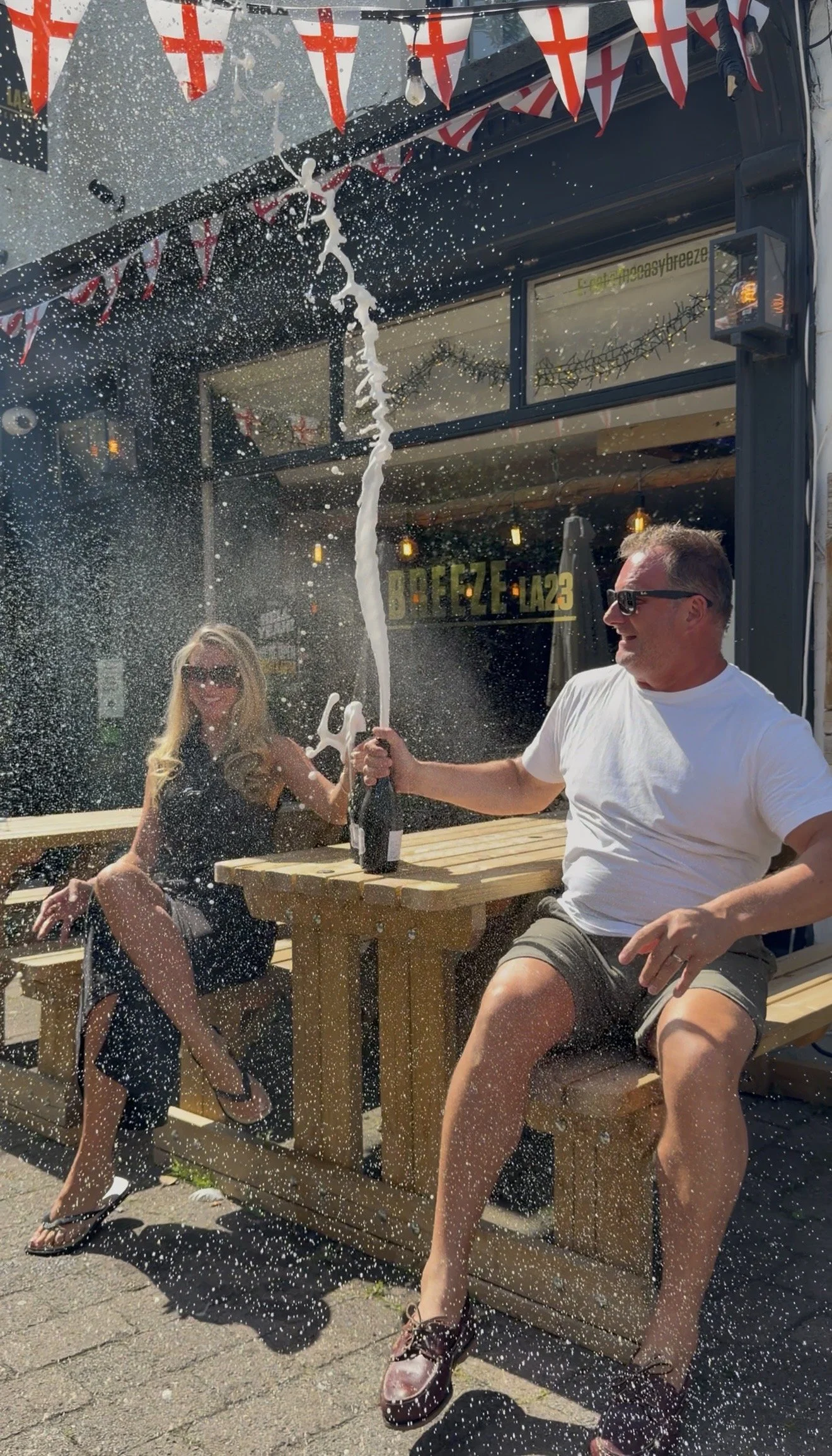 two people smashing prosecco outside the easy breeze