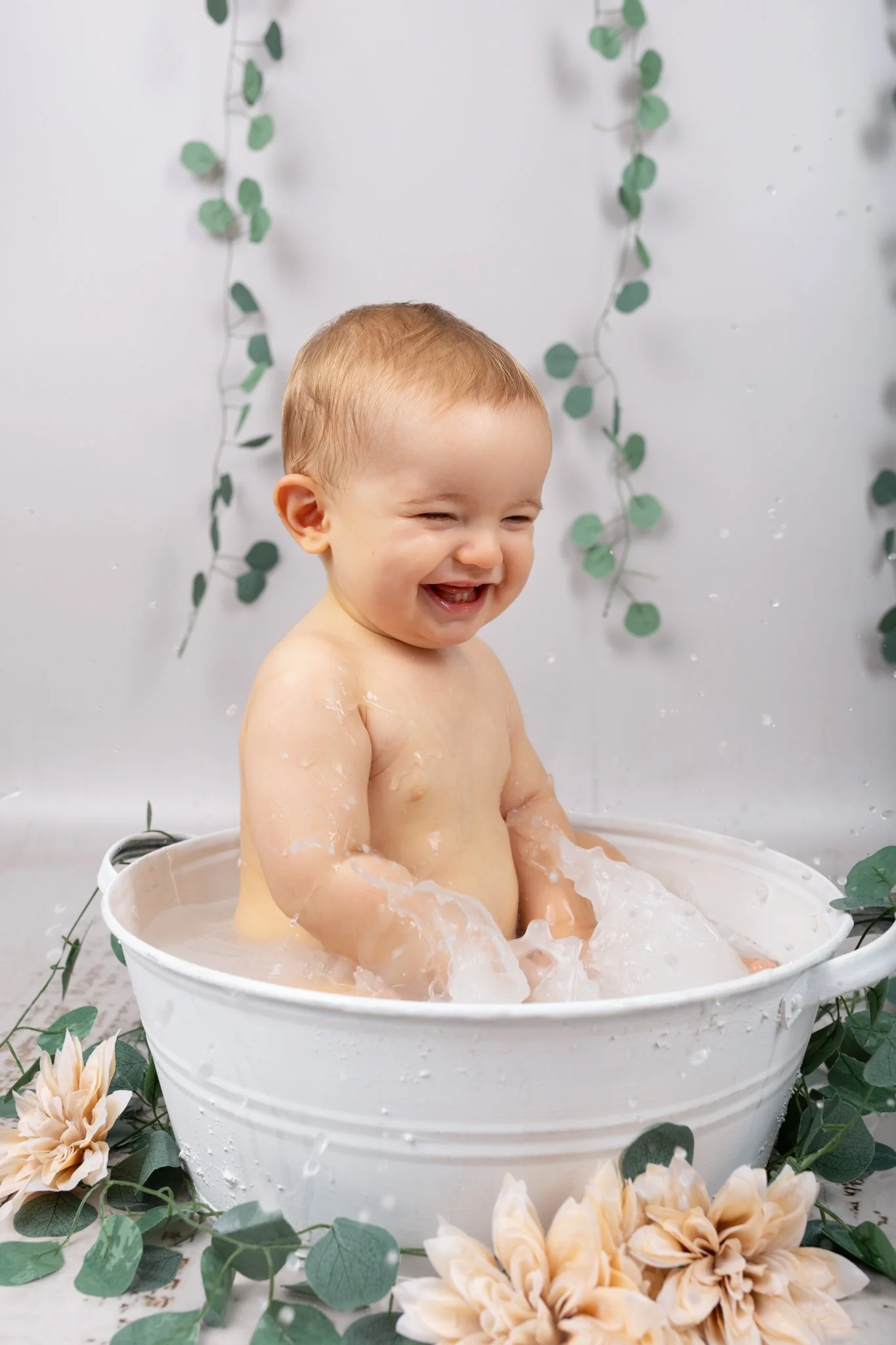 Séance photo bain de lait Yvelines - enfant dans un bain de lait rigole en tapant dans l'eau