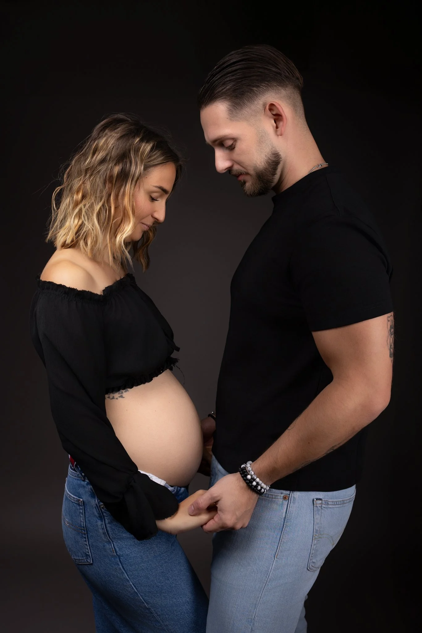 Séance photo grossesse Yvelines - future maman et papa regards vers le ventre main dans la main