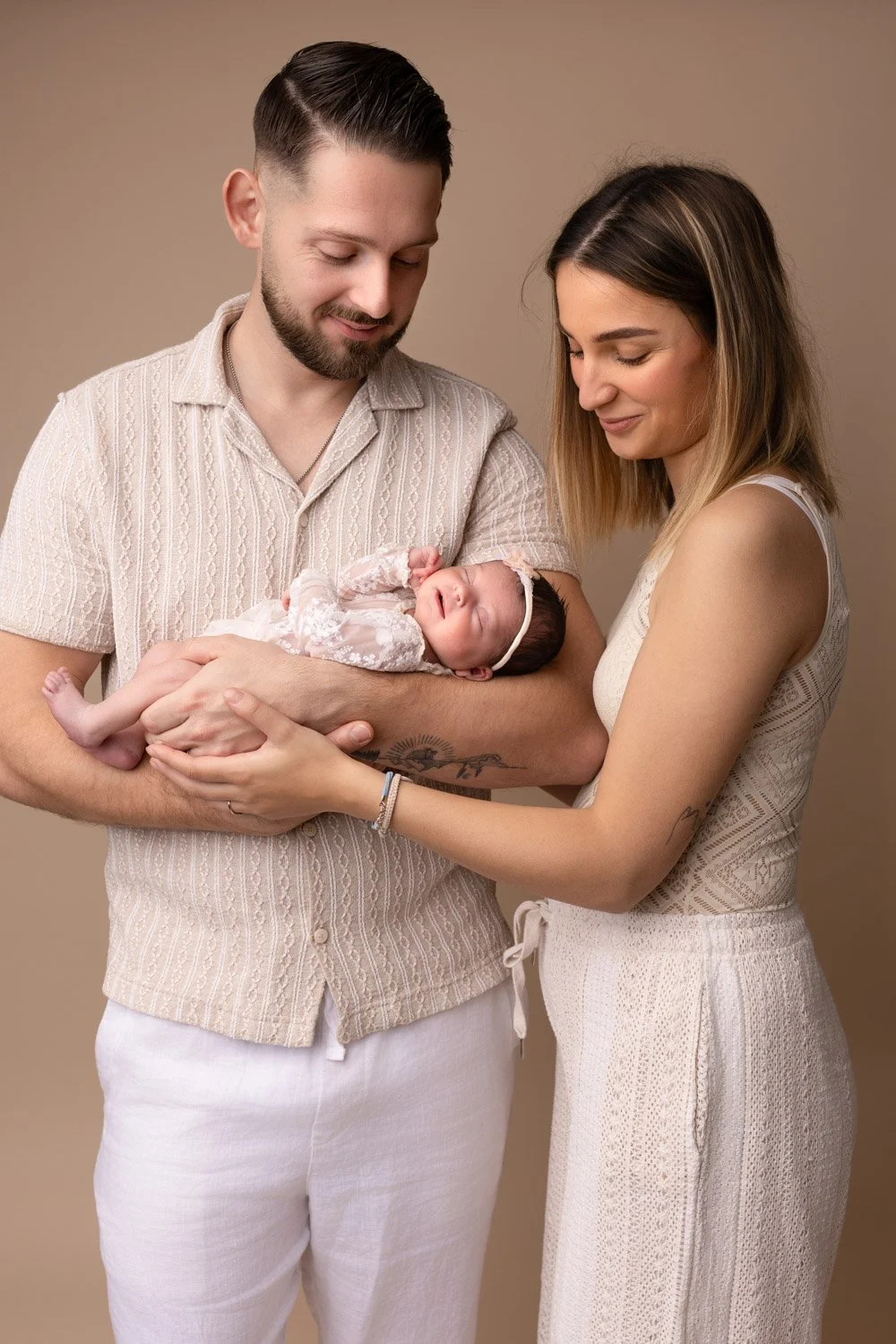 Séance photo naissance Yvelines - bébé dans les bras de ses parents, sourire inconscient 