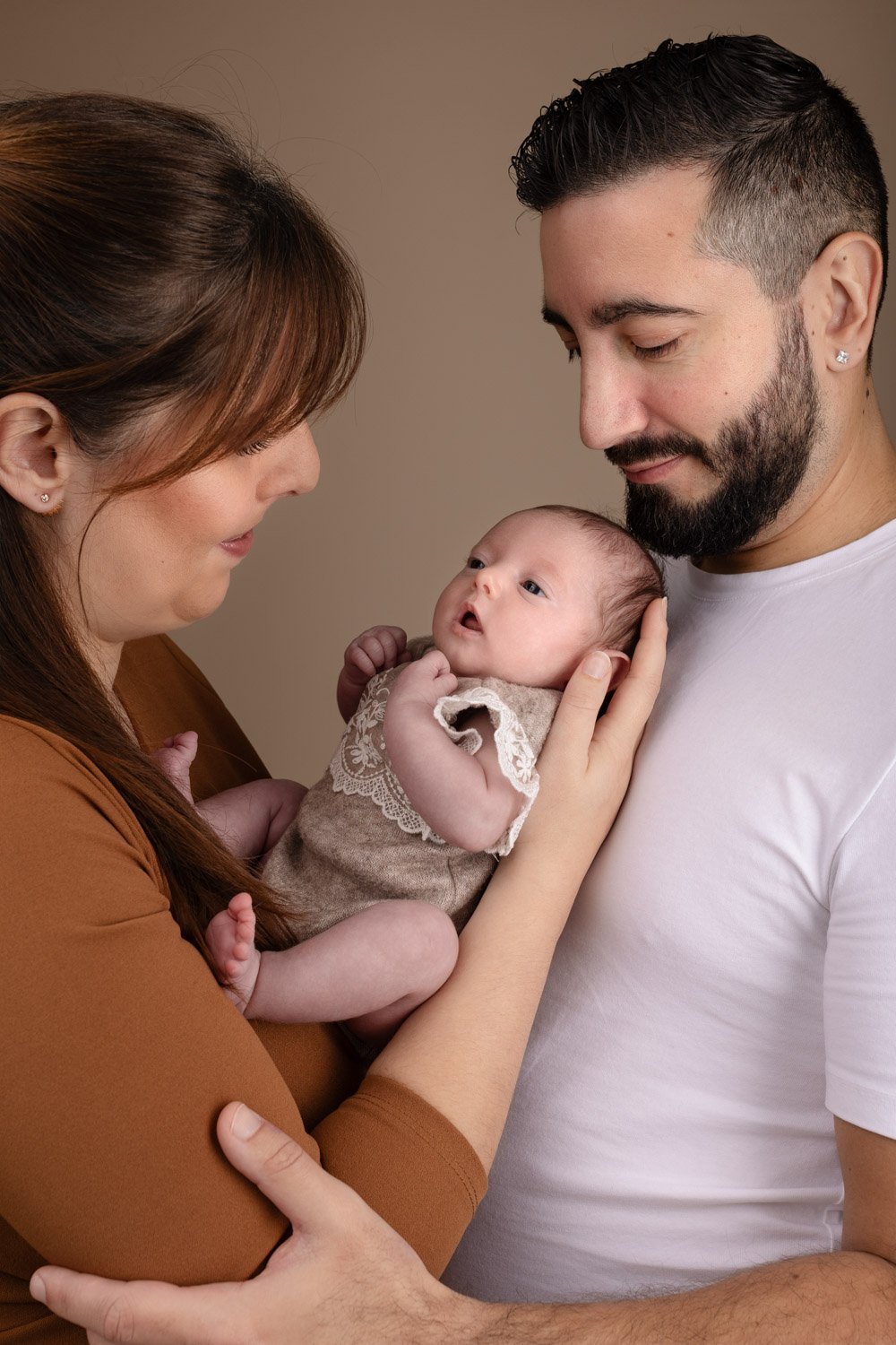 Séance photo naissance Yvelines - bébé dans les bras de ses parents donc beige chaleureux 