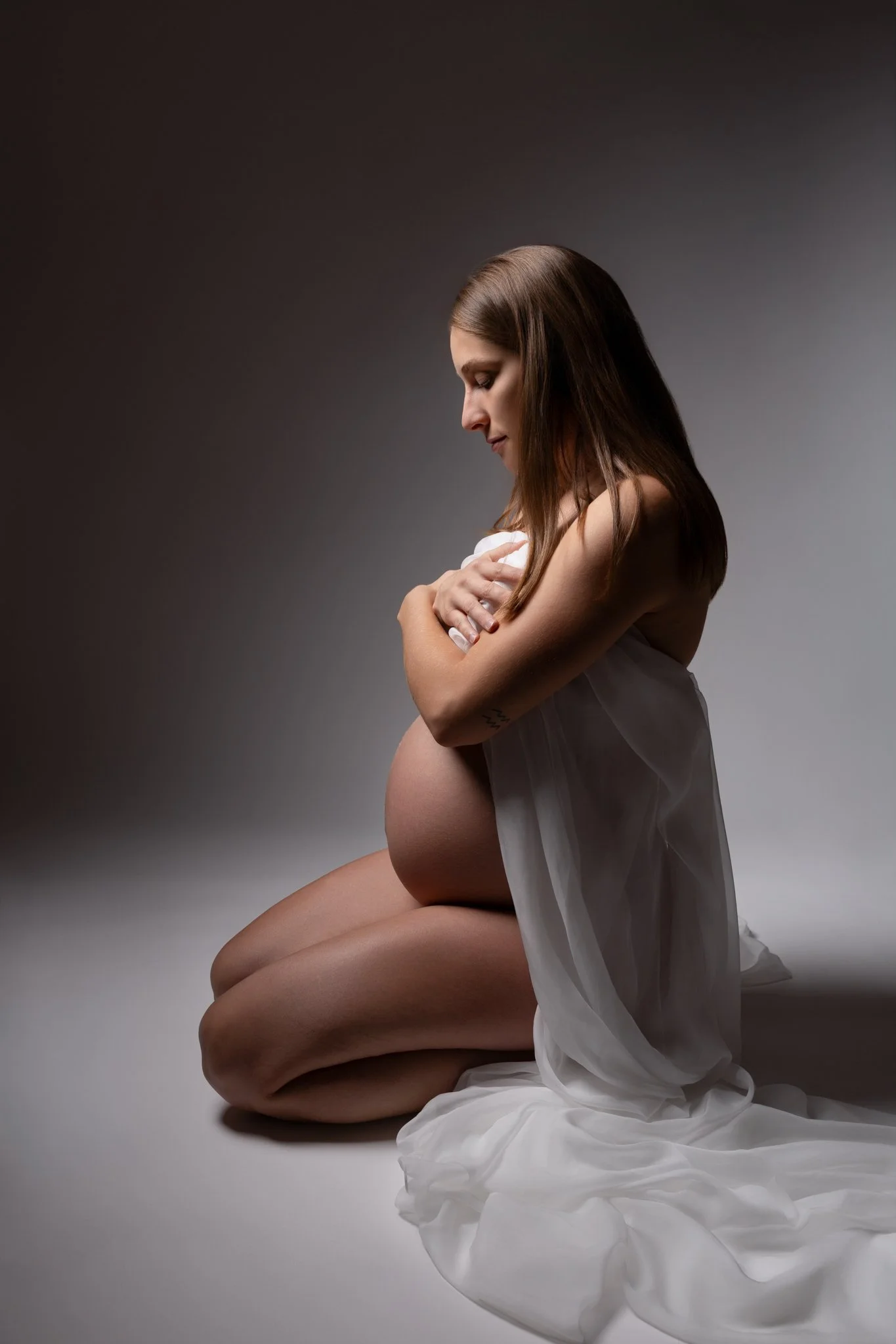 Séance photo grossesse Yvelines - future maman à genou robe longue blanche 