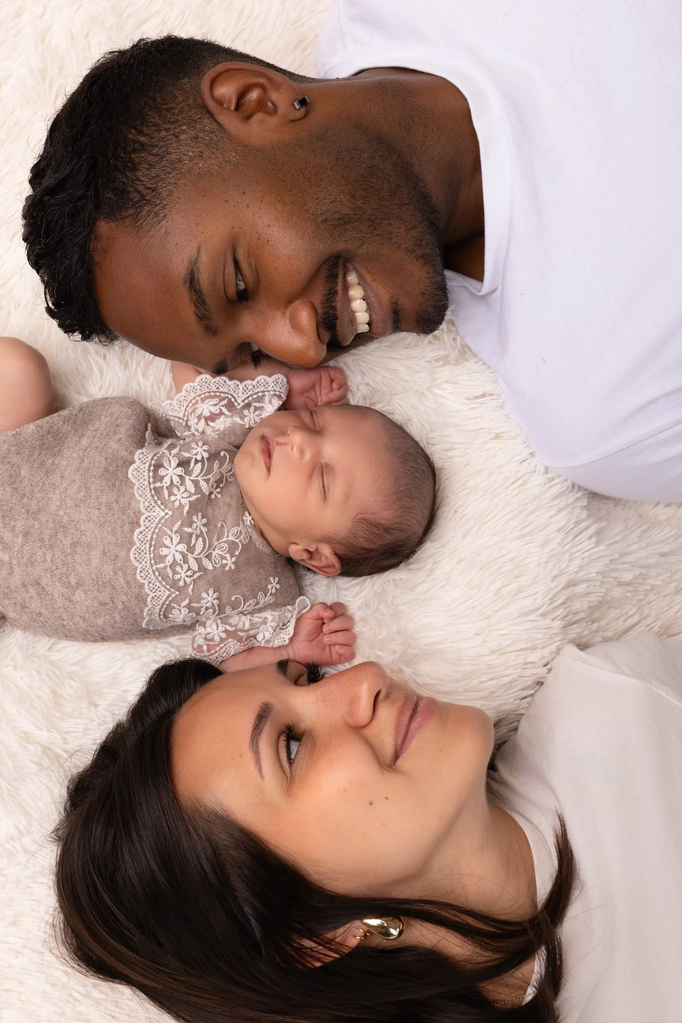 Séance photo naissance Yvelines - famille allongé sur une couverture regard vers bébé