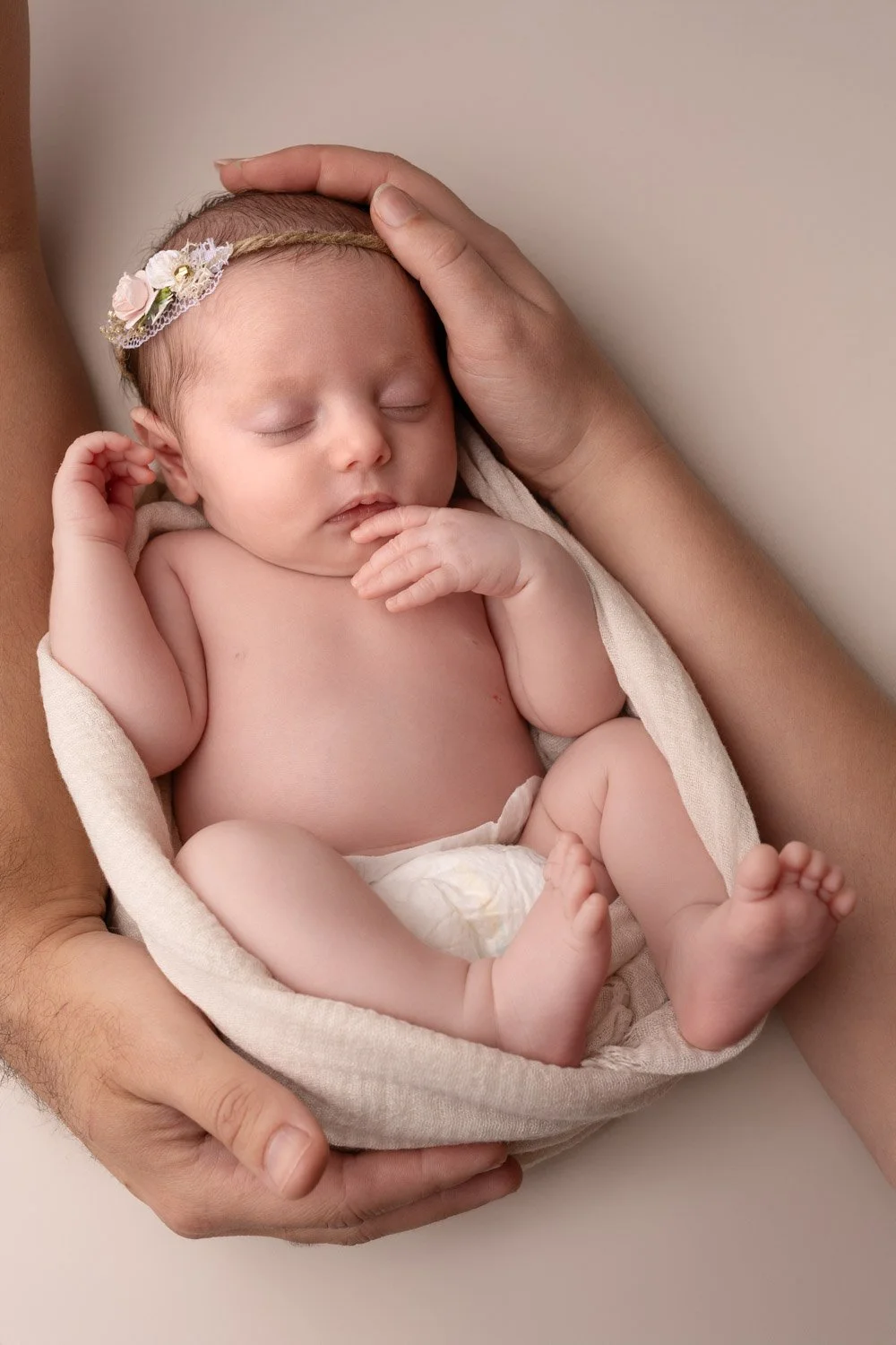 Séance photo naissance Yvelines - bébé en cocon entre les bras de ses parents