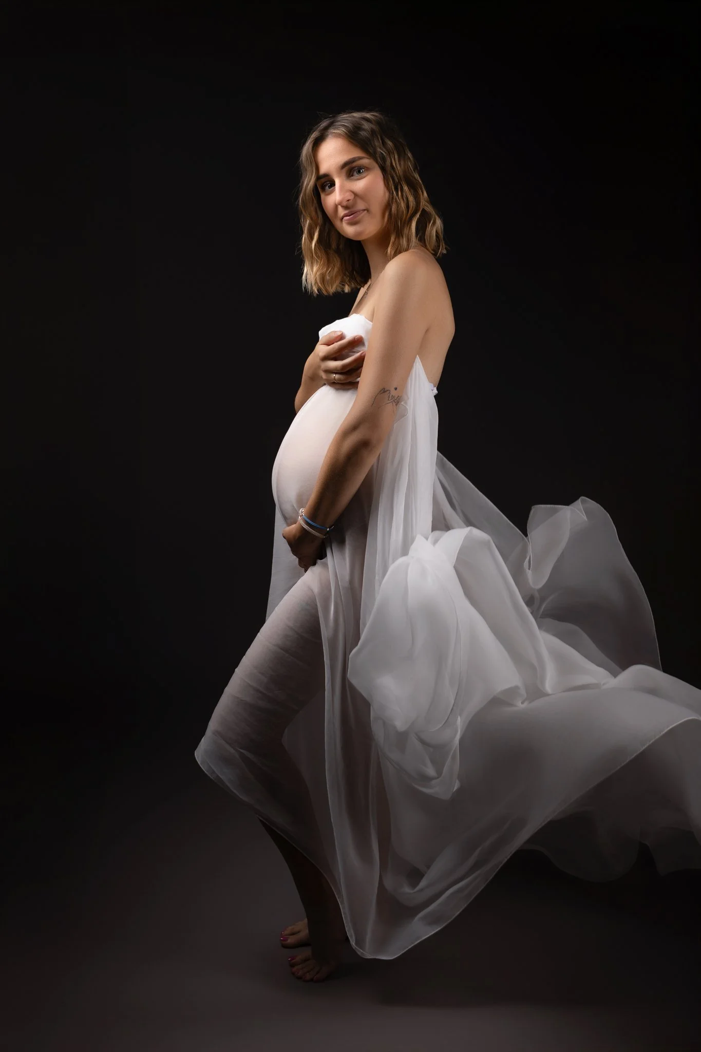 Séance photo grossesse Yvelines - future maman avec un voile blanc volant