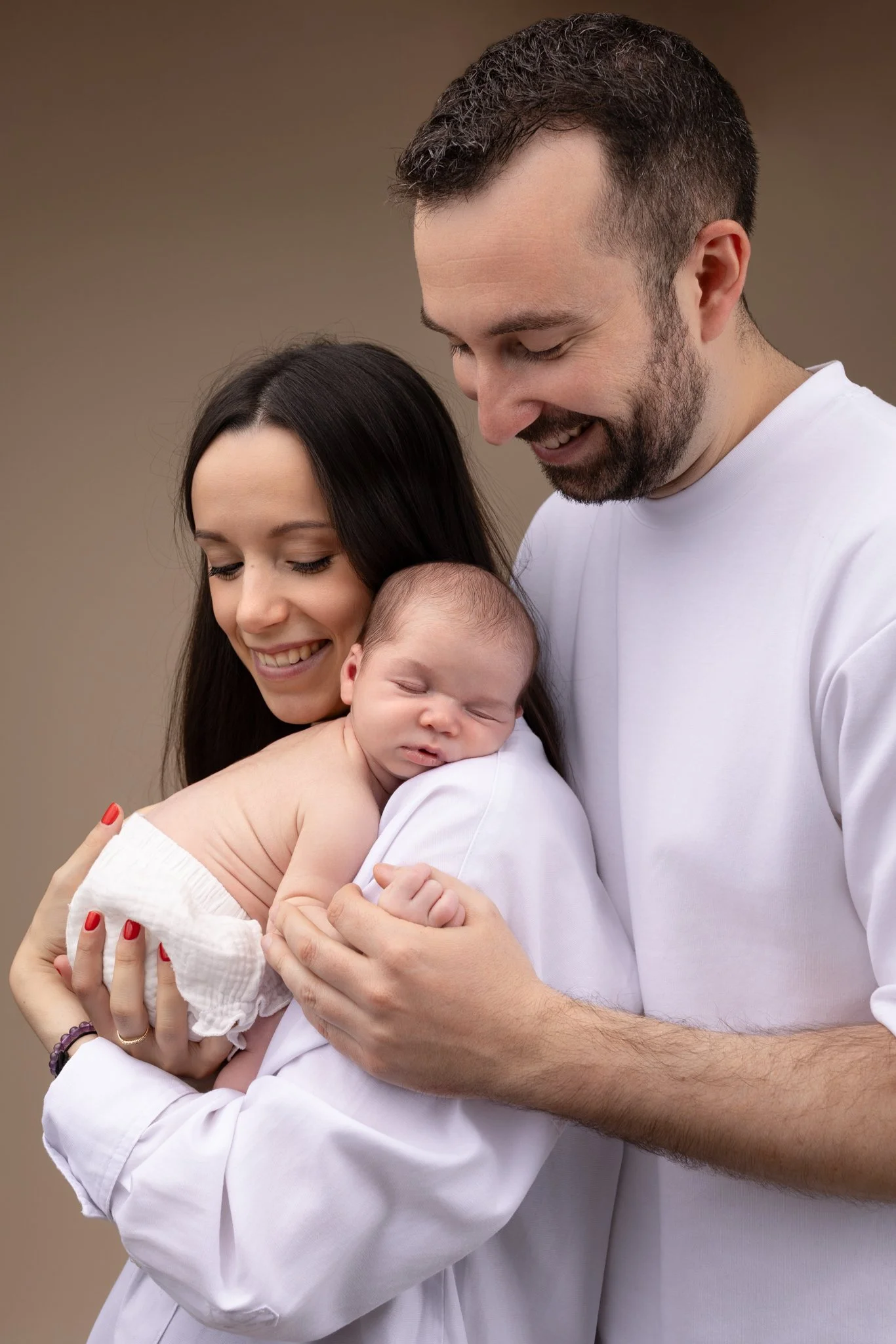 Séance photo naissance Yvelines - les parents et leur bébé dans les bras endormi