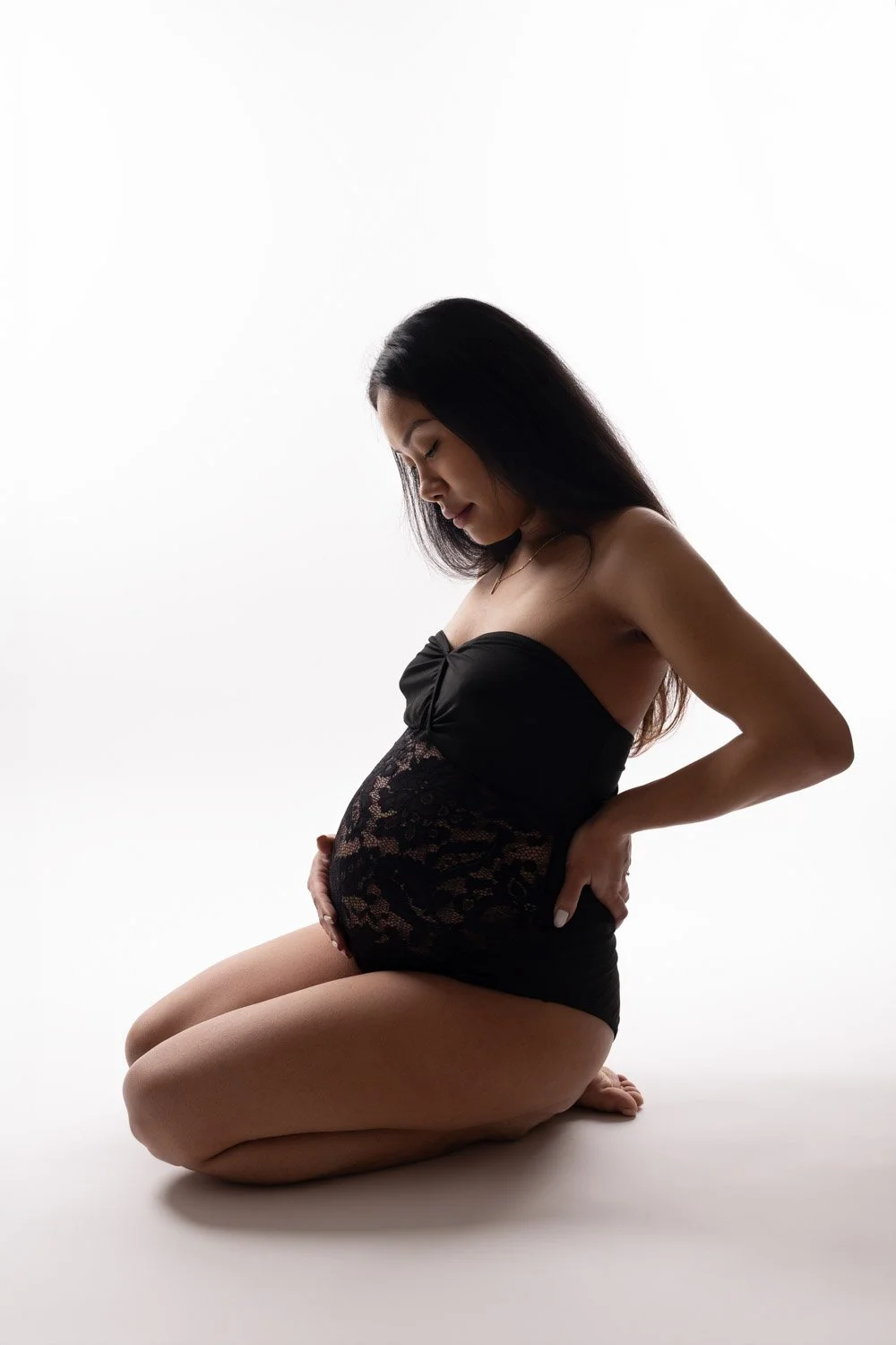 Séance photo grossesse Yvelines - future maman, fond blanc pur, body dentelle noir