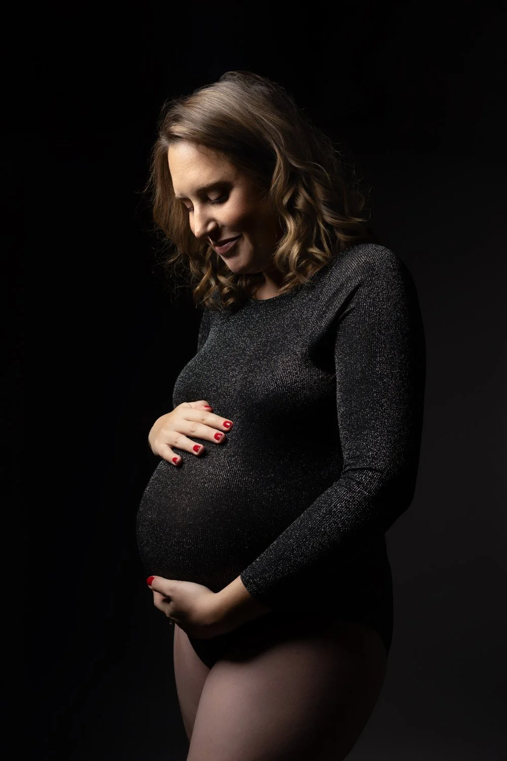 Séance photo grossesse Yvelines - future maman body noir paillette, mains entourant le ventre
