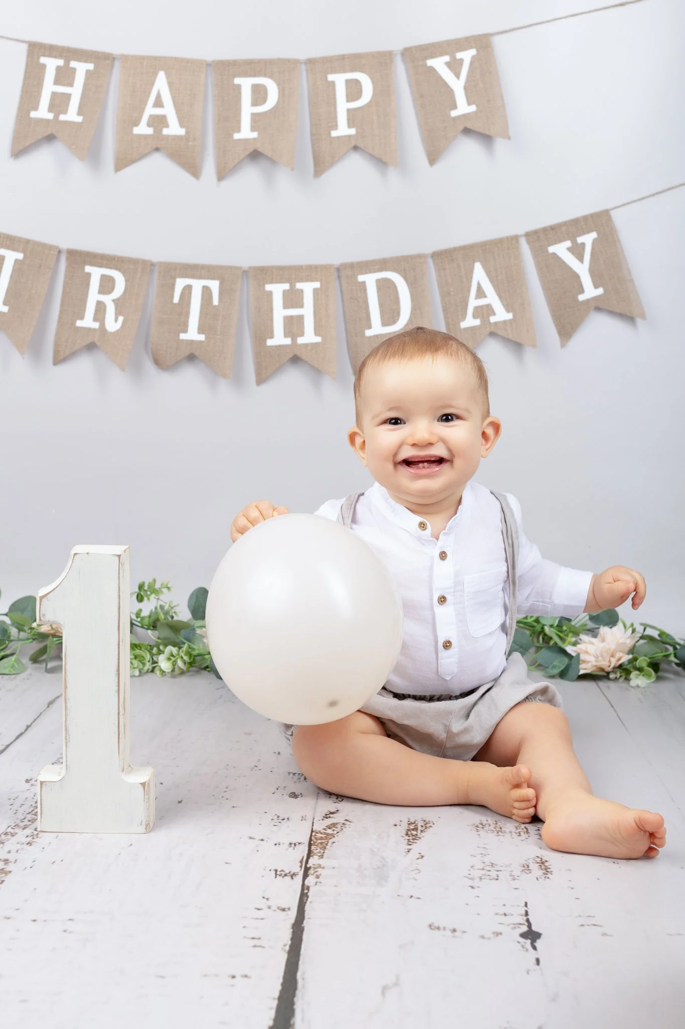 Séance photo anniversaire Yvelines - décor naturel, petit garçon avec un 1 en bois et un ballon