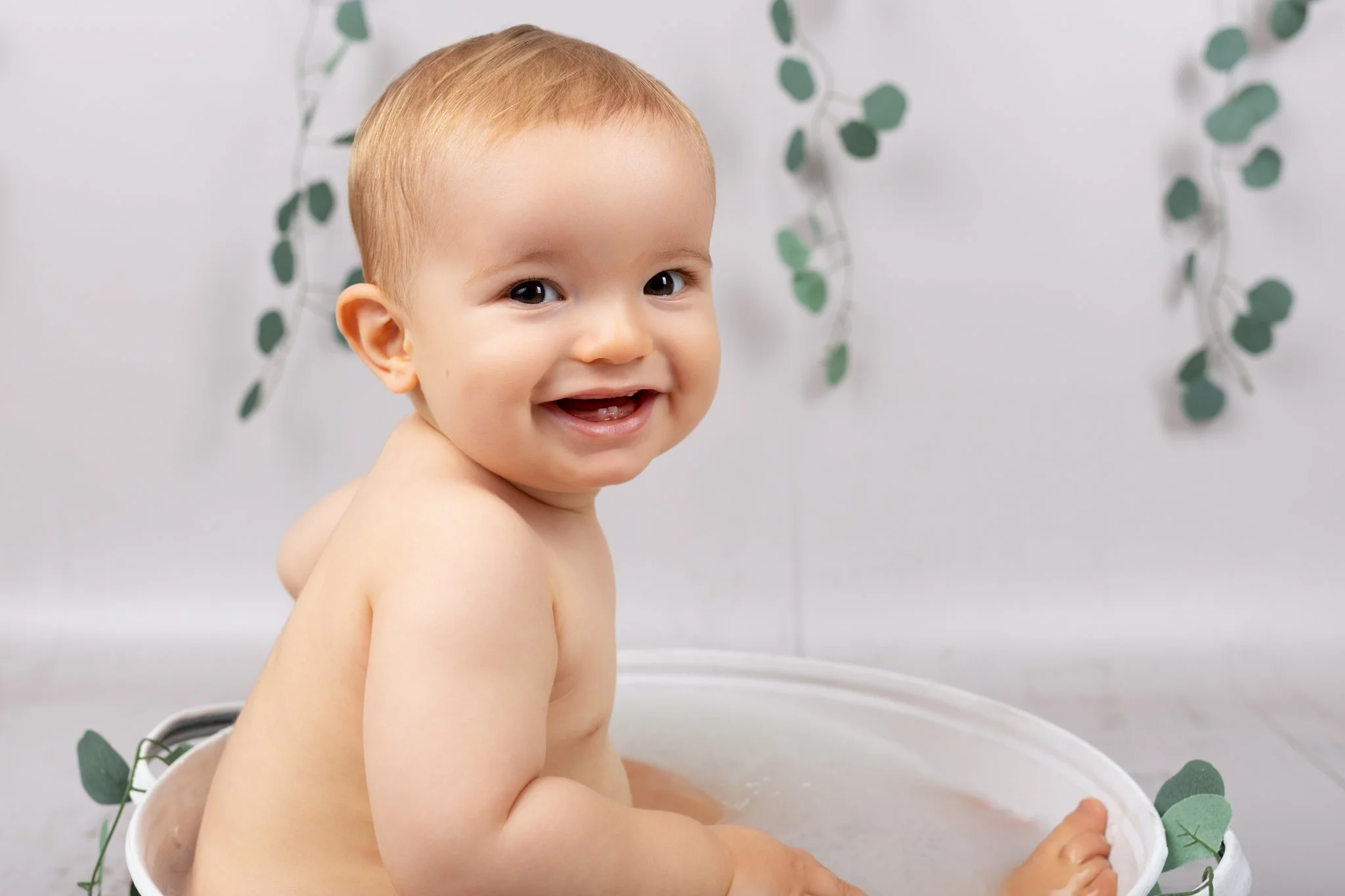 Séance photo bain de lait Yvelines - enfant dans un bain de lait, gros plan, souriant 