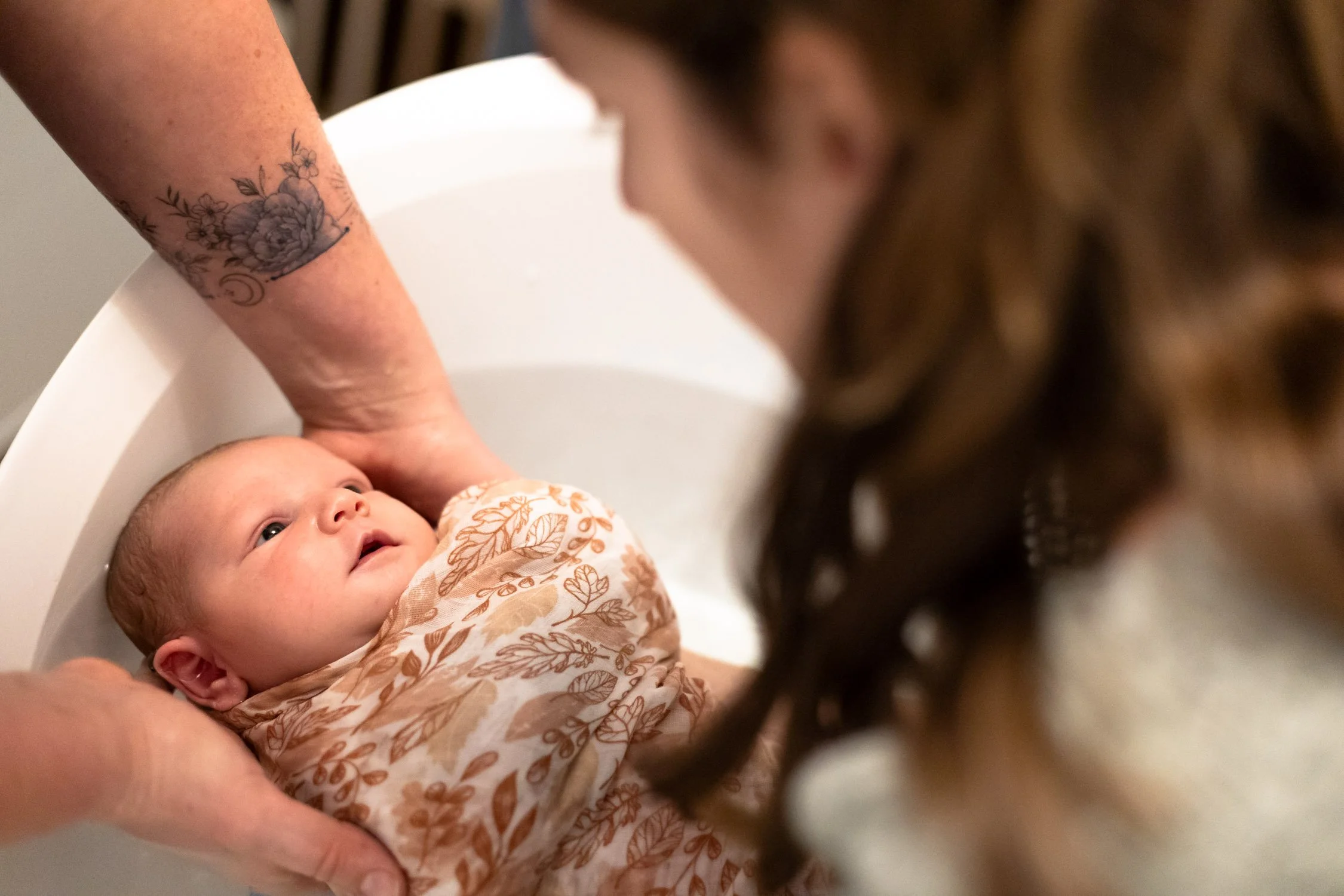 bébé dans son bain regard vers sa maman