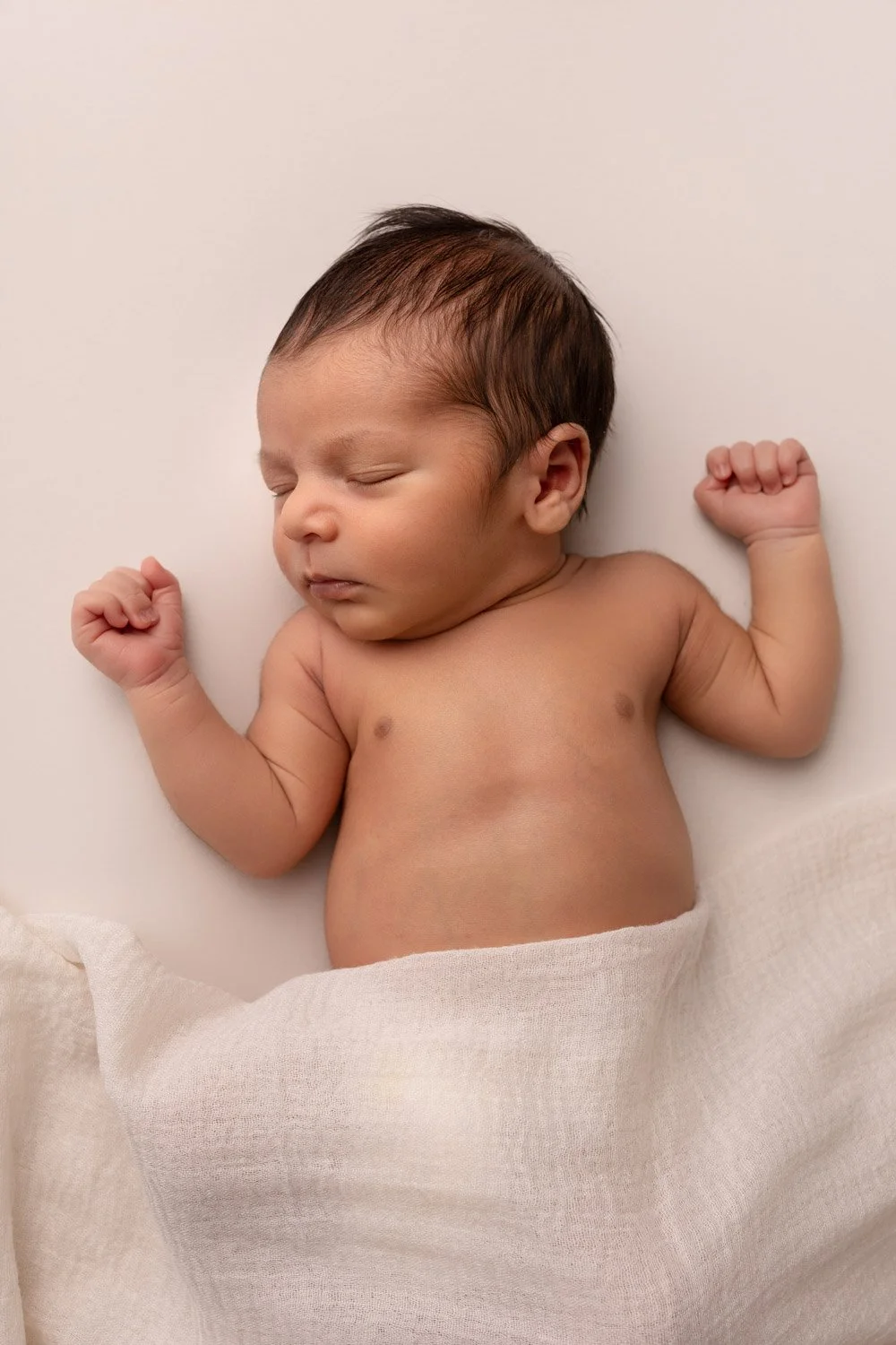 Séance photo naissance Yvelines - bébé à plat dos, endormi, avec une couverture beige