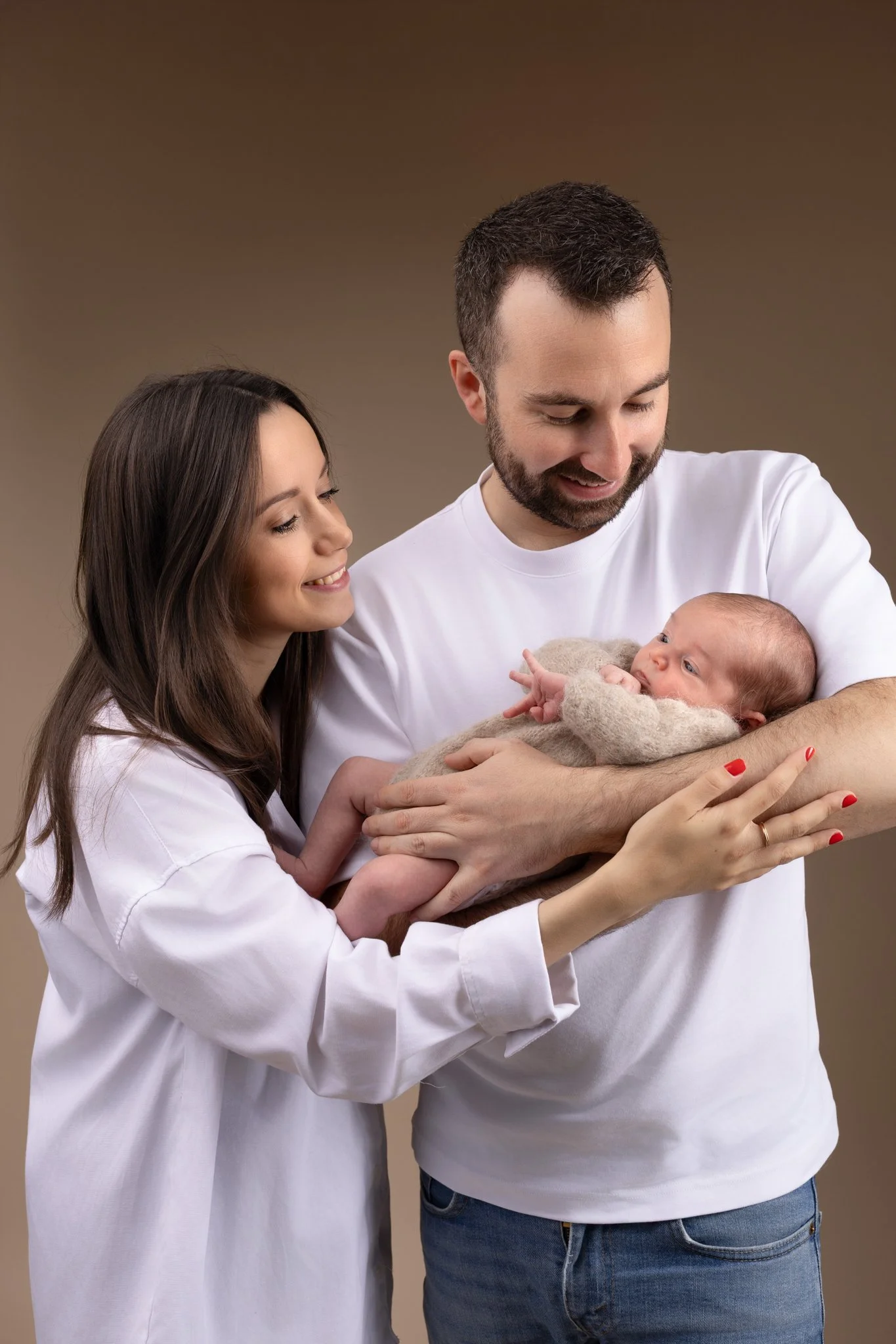 Séance photo naissance Yvelines - bébé dans les bras du papa et maman à coté 