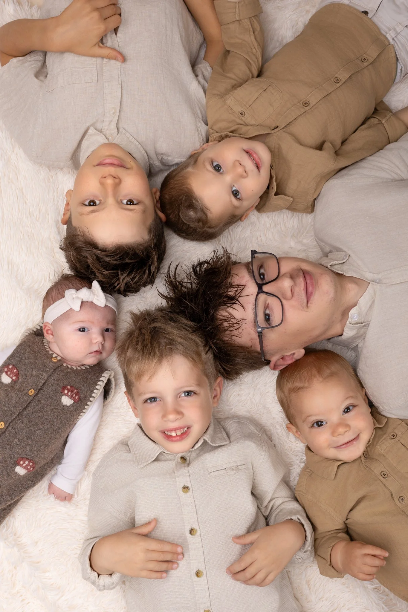 Séance photo famille Yvelines – famille avec 6 enfants allongés au sol regard vers le haut