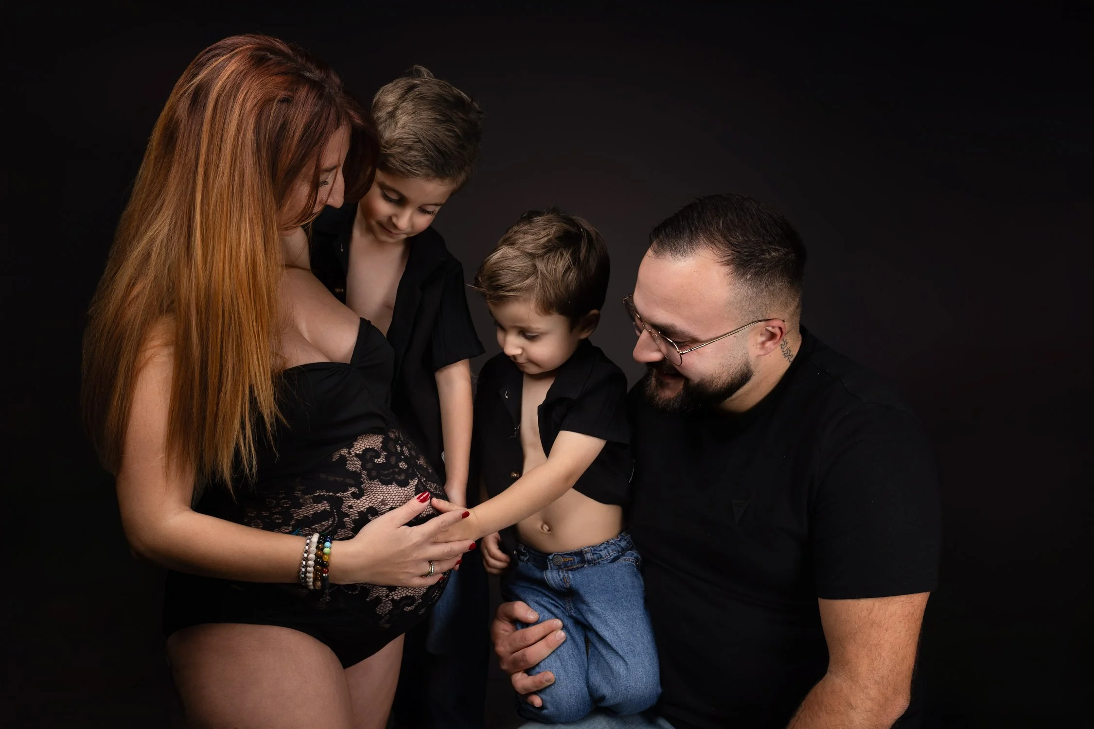 Séance photo grossesse Yvelines - famille attendant le 3eme bébé, tous regards vers le ventre