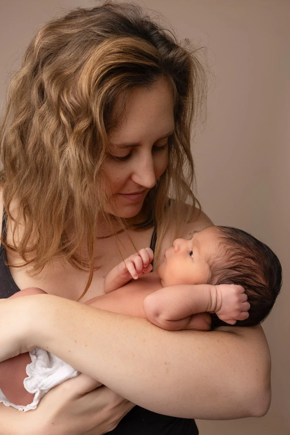 Séance photo naissance Yvelines - maman porte son bébé et regard vers lui