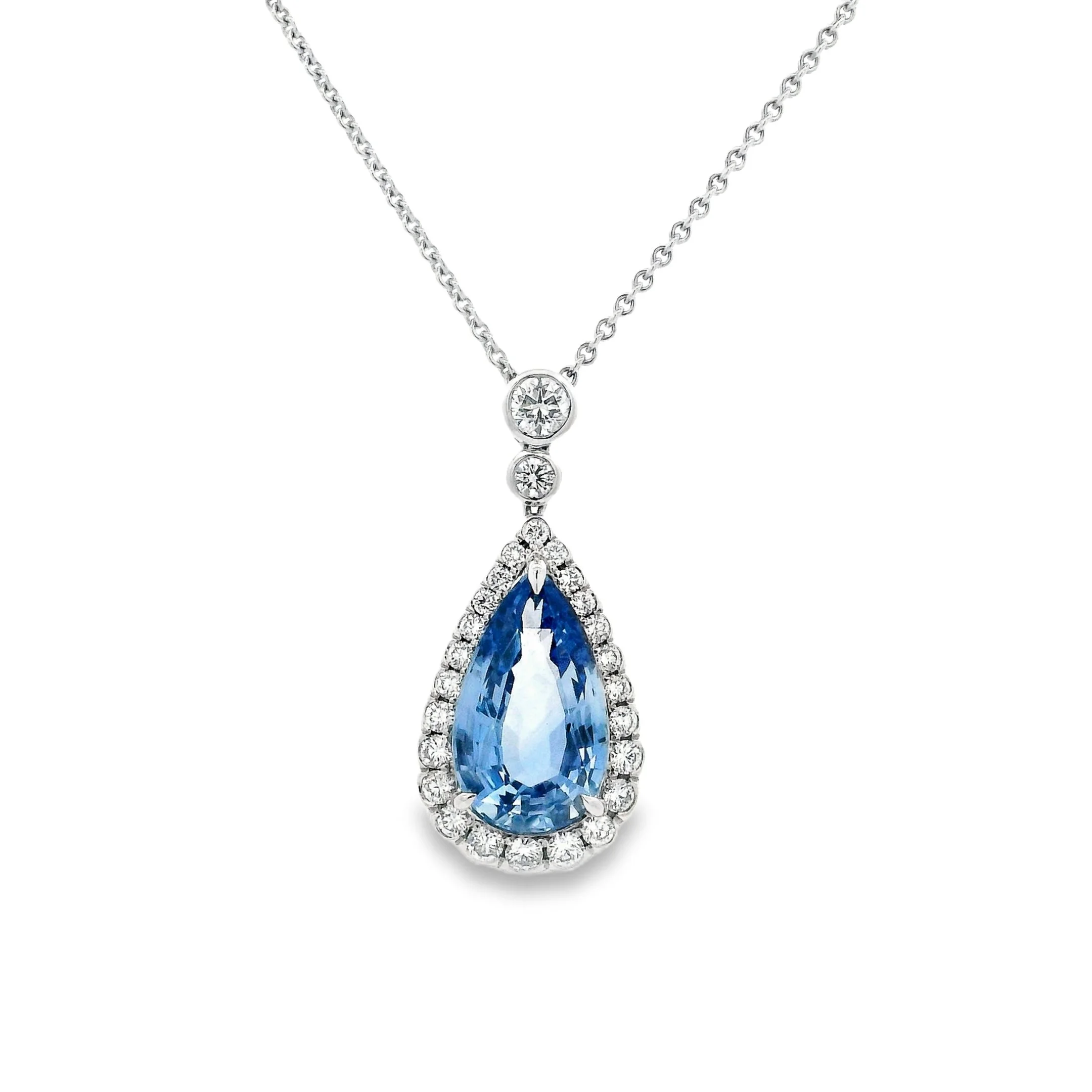 Silver necklace with a large teardrop-shaped blue gemstone surrounded by small diamonds.