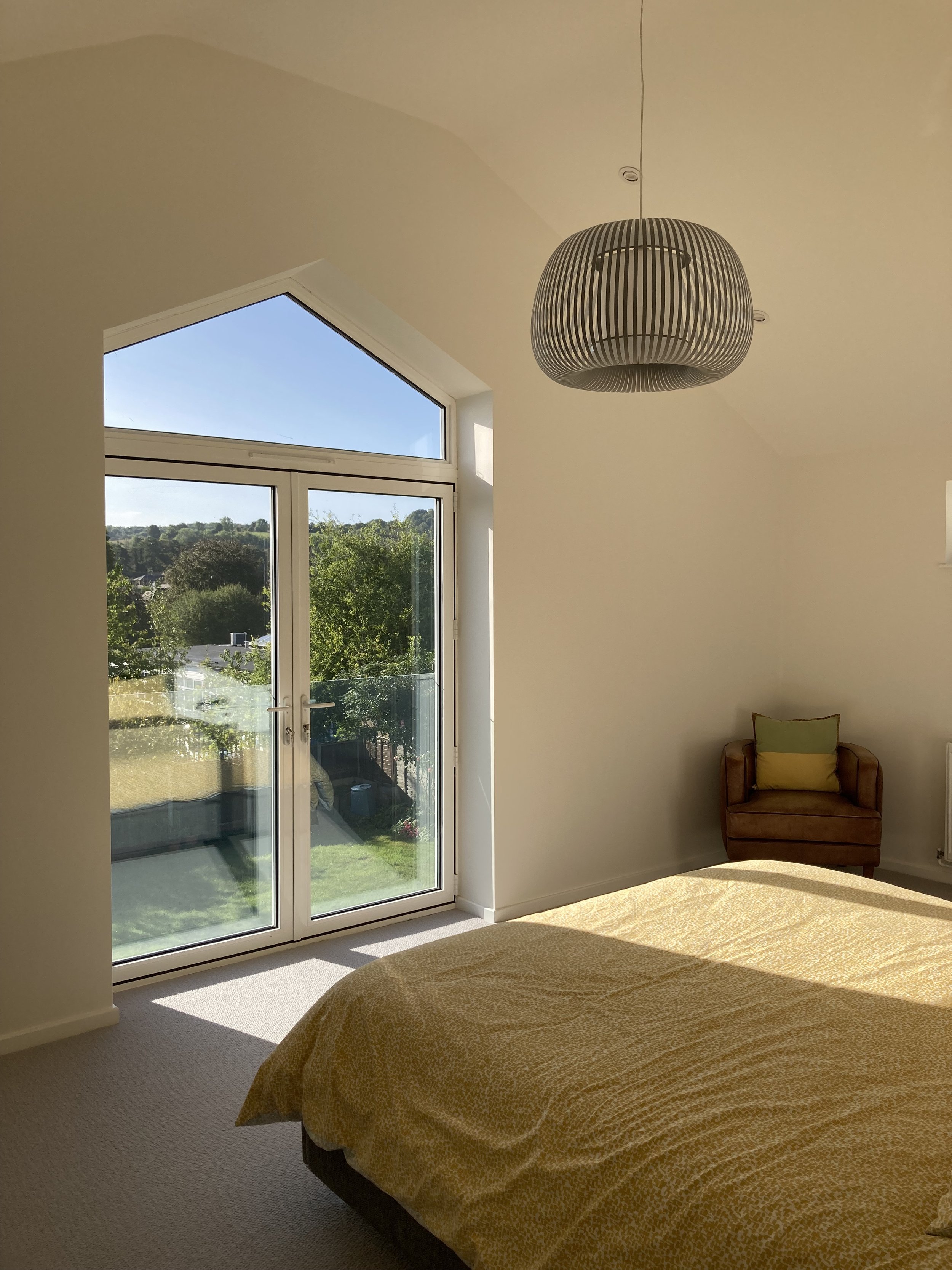 The master bedroom has a high vaulted ceiling with a feature window.