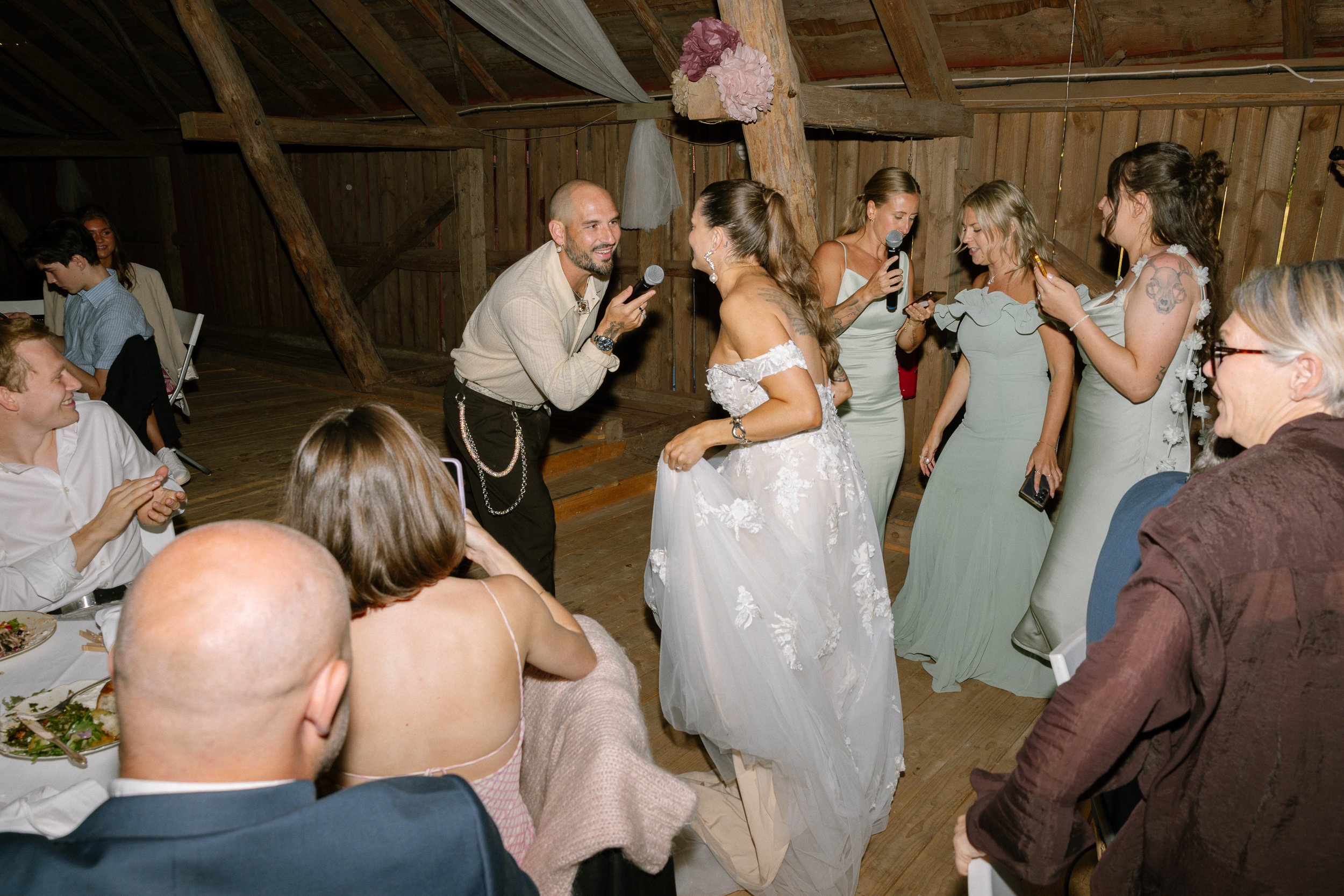 Brudpar dansar på ett bröllop, omgivna av vänner och familj i en loge.  Av Sofia Wilhelmina bröllopsfotograf i Stockholm.