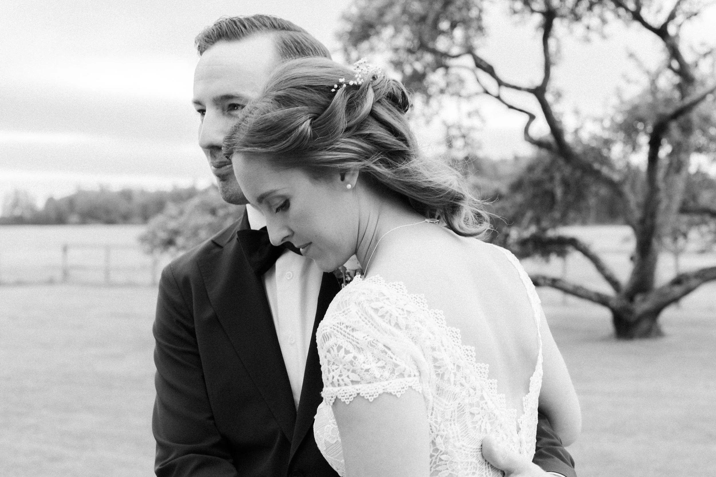 brudpar står och ser allvarligt ut mot vänster i bild, editorial känsla, svartvit