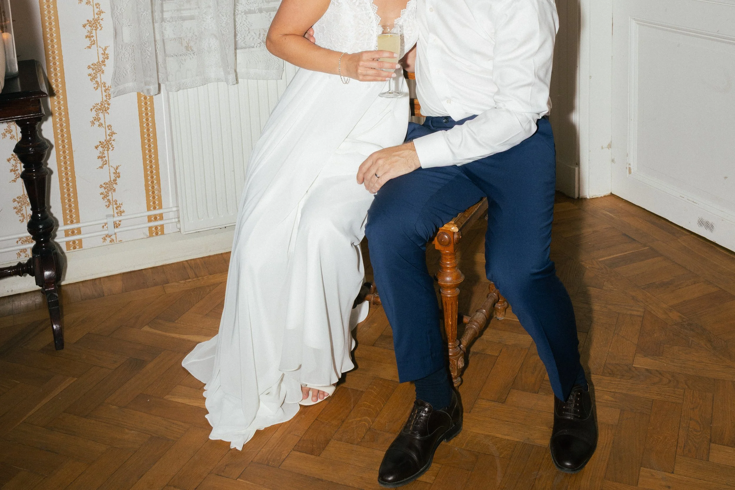 bild på brud och brudgum som sitter på en stol vid dansgolvet, man kan inte se deras ansikten som är utanför bild