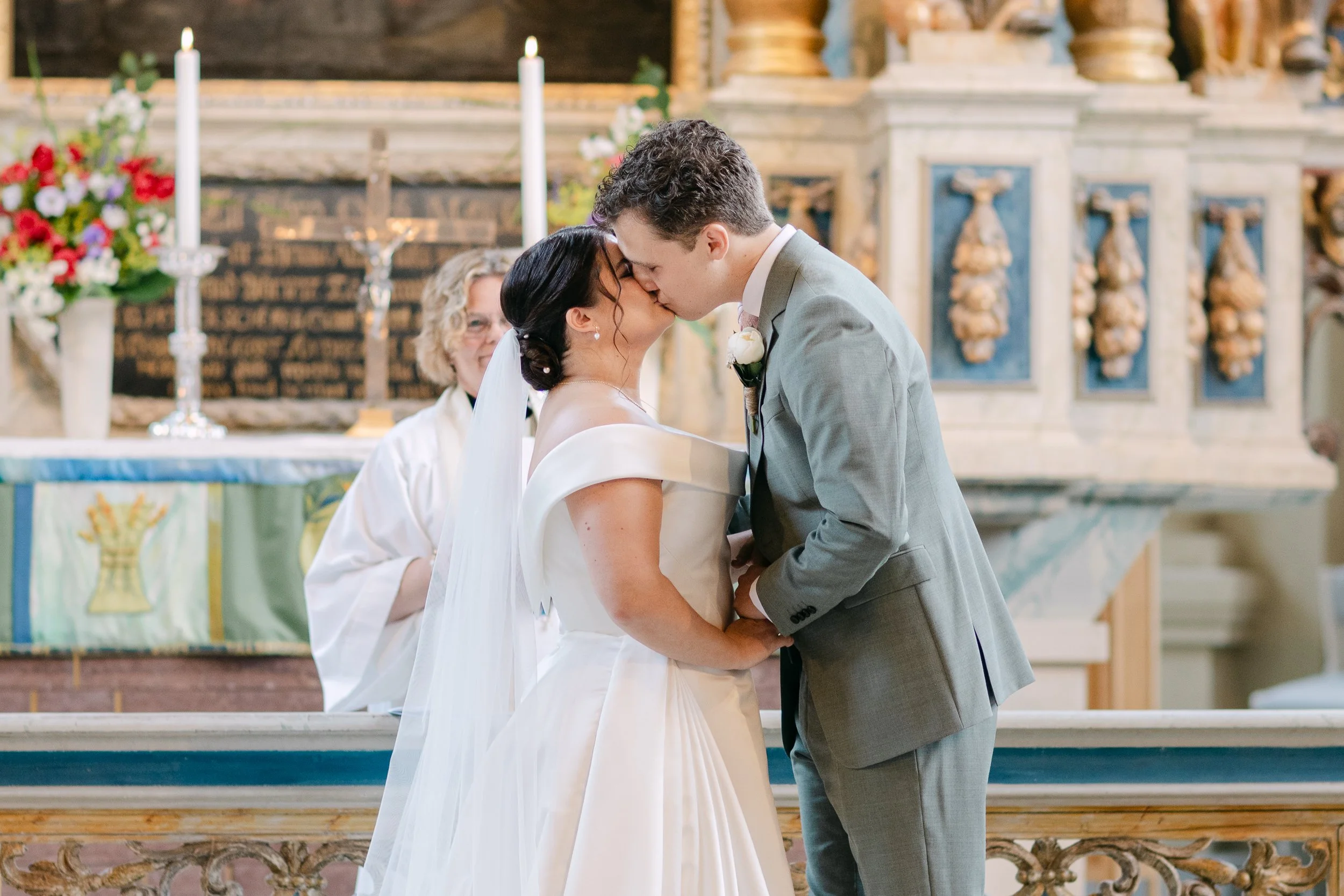 Ett brudpar kysser varandra i en kyrka under deras bröllopsceremoni.