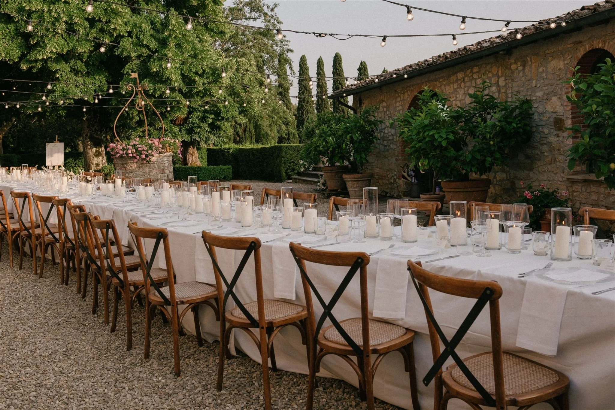 Outdoor wedding dinner setup with wooden chairs in Tuscany