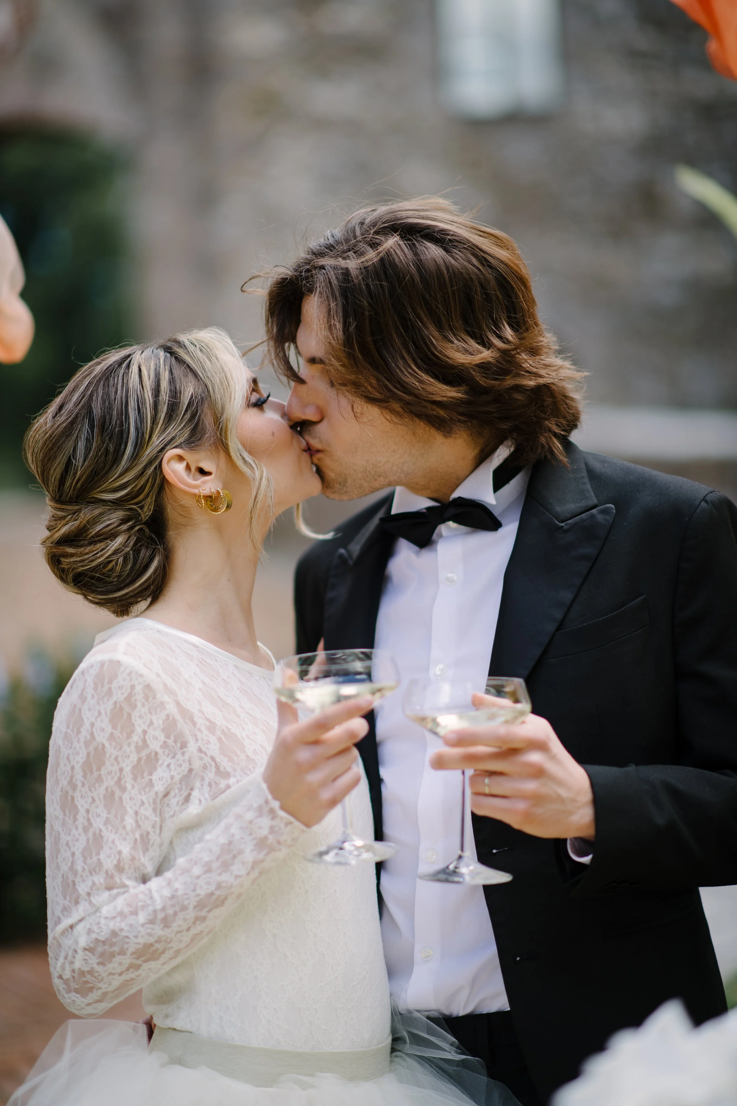 bride and groom drinking prosecco and kissing
