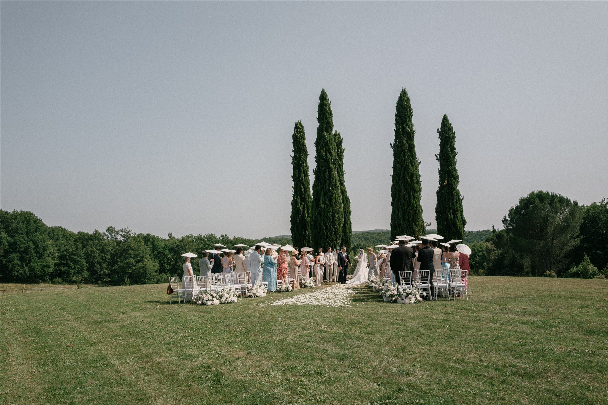 Multicultural wedding ceremony setup overlooking Tuscan countryside