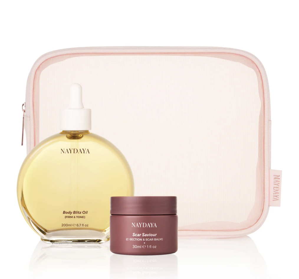 A set of skincare products including a yellow oil in a clear round bottle with a white dropper cap, a small pink jar labeled 'Scar Saviour', and a pink zippered cosmetic bag in the background.