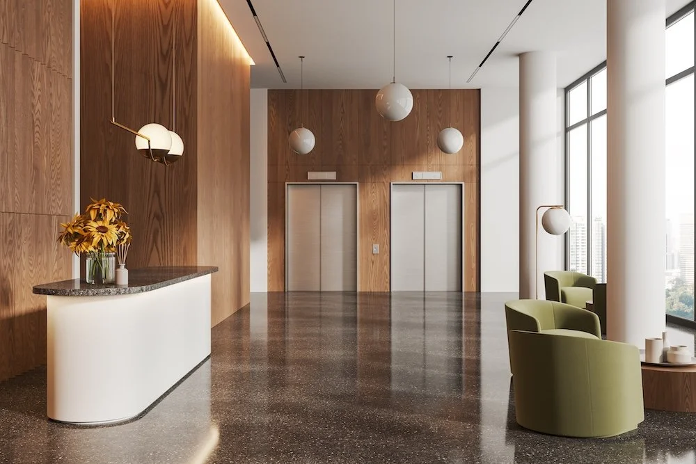 elegant condominium entryway with elevators and a reception desk