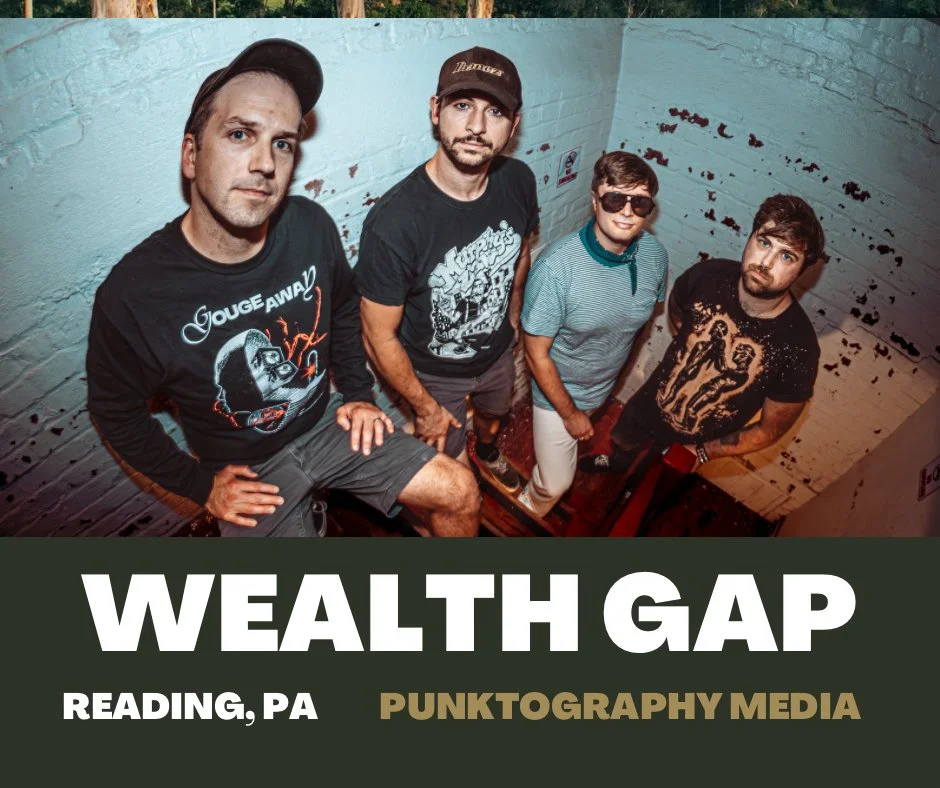 Four men pose for a photo in a small, painted brick room. They are looking up at the camera, with two wearing graphic T-shirts and one in glasses. The bottom text reads 'WEALTH GAP, READING, PA, PUNKTOGRAPHY MEDIA'.