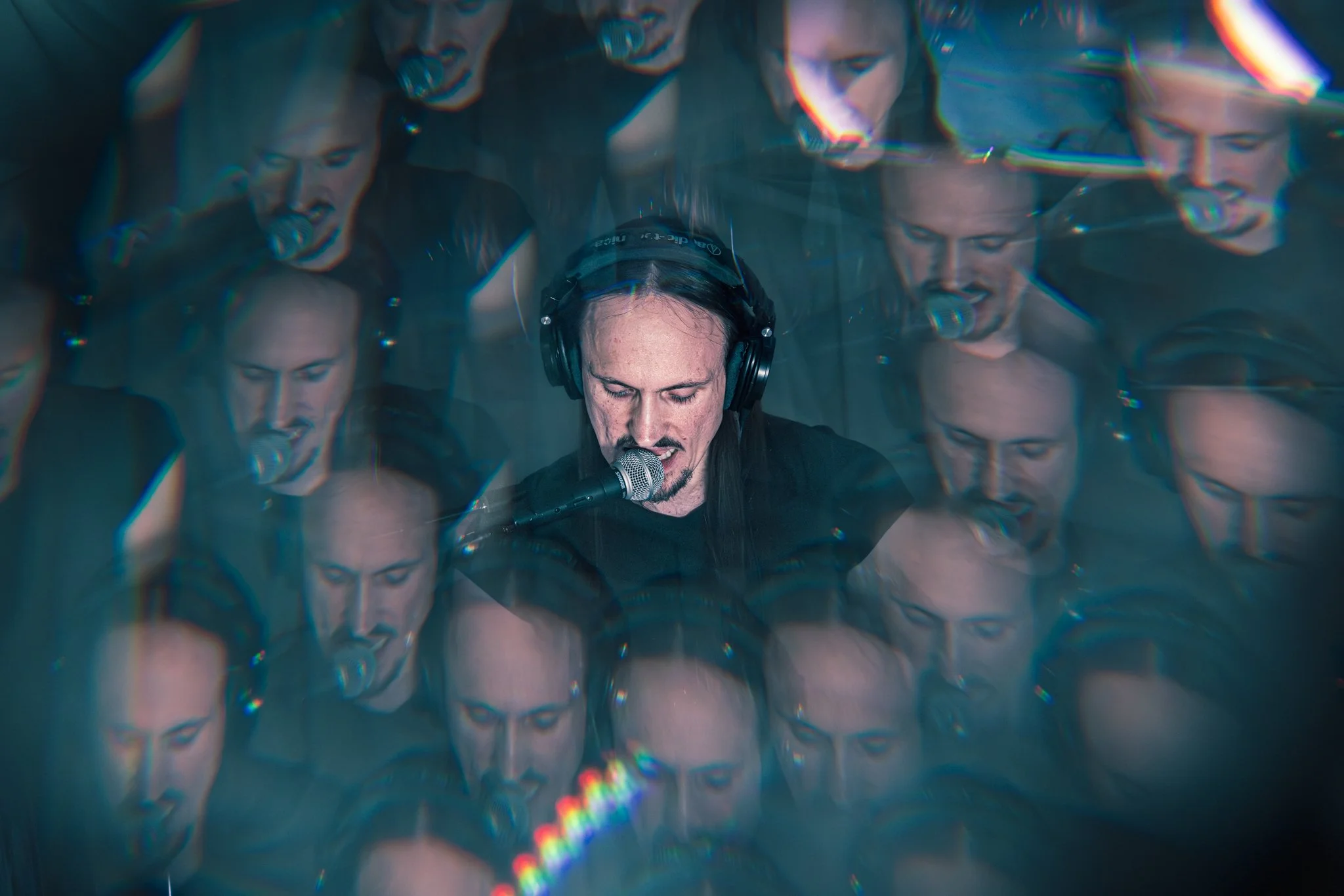 A person singing into a microphone with multiple blurred repetitions of their face and headphones around their head.