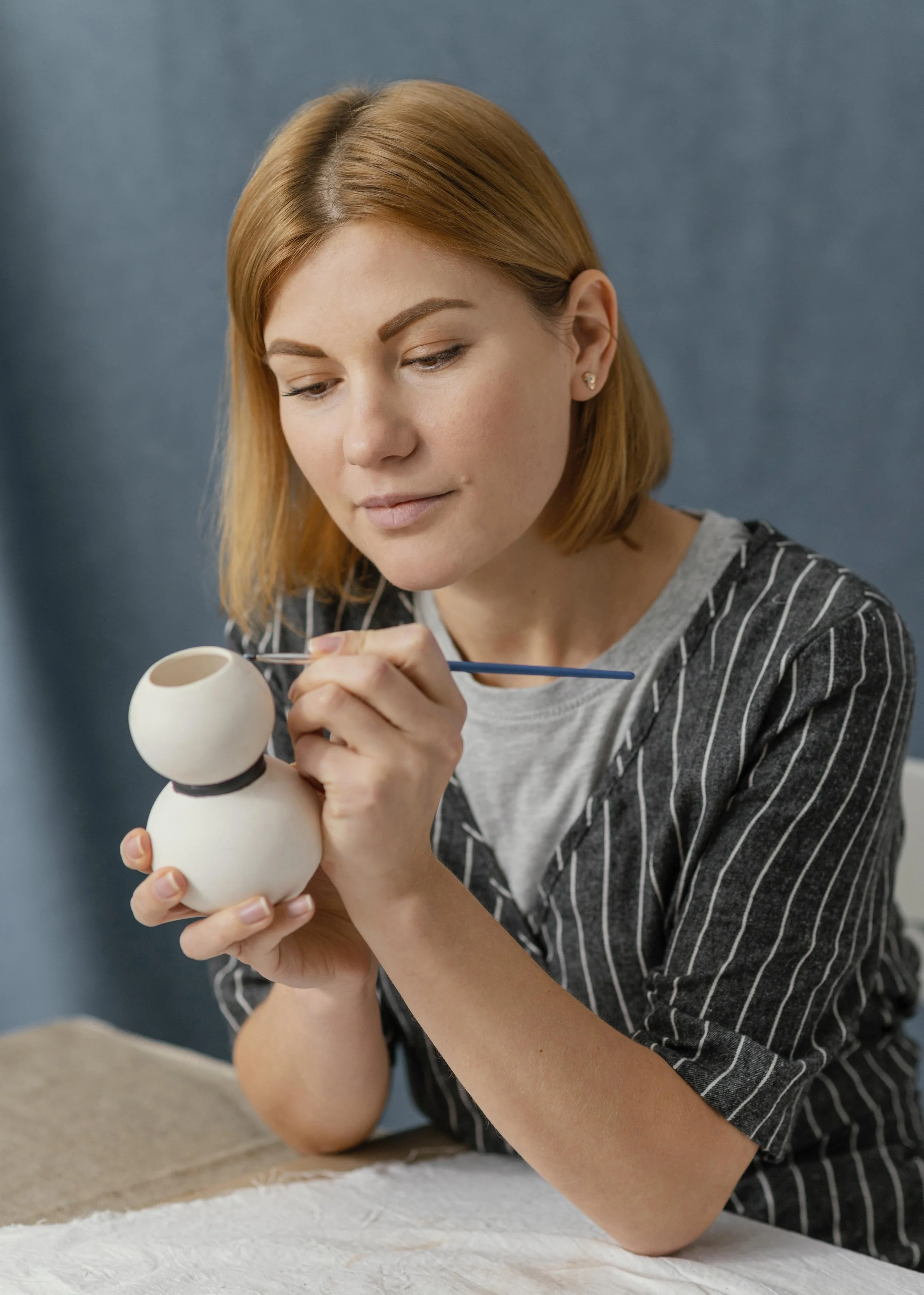 medium-shot-woman-painting-pottery-item.jpg
