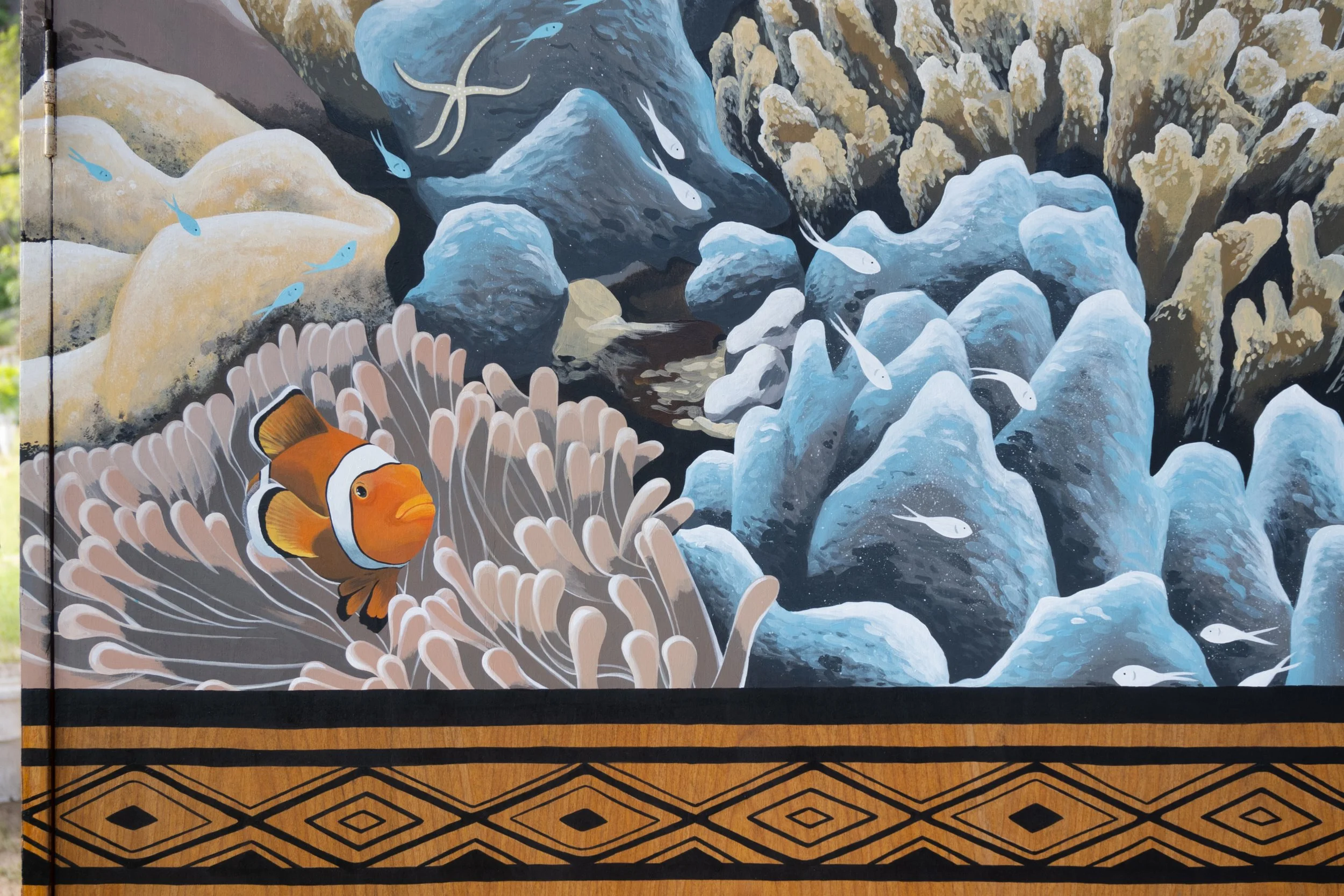 Kirana Retreat - A lively underwater scene featuring a variety of marine species. Painted on a wooden closet used to store watersport equipment at the resorts  watersport centre.